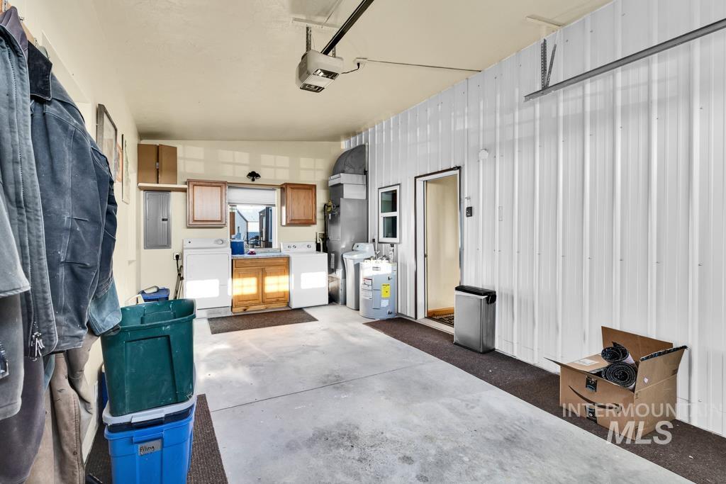 Garage with electric panel, independent washer and dryer, and a garage door opener