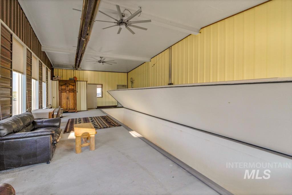 Below grade area with a ceiling fan and wooden walls