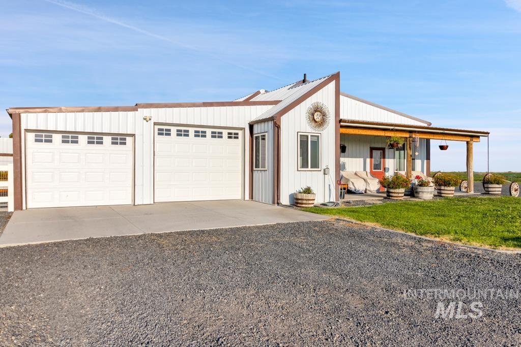 View of front of home featuring a porch, driveway, and a garage