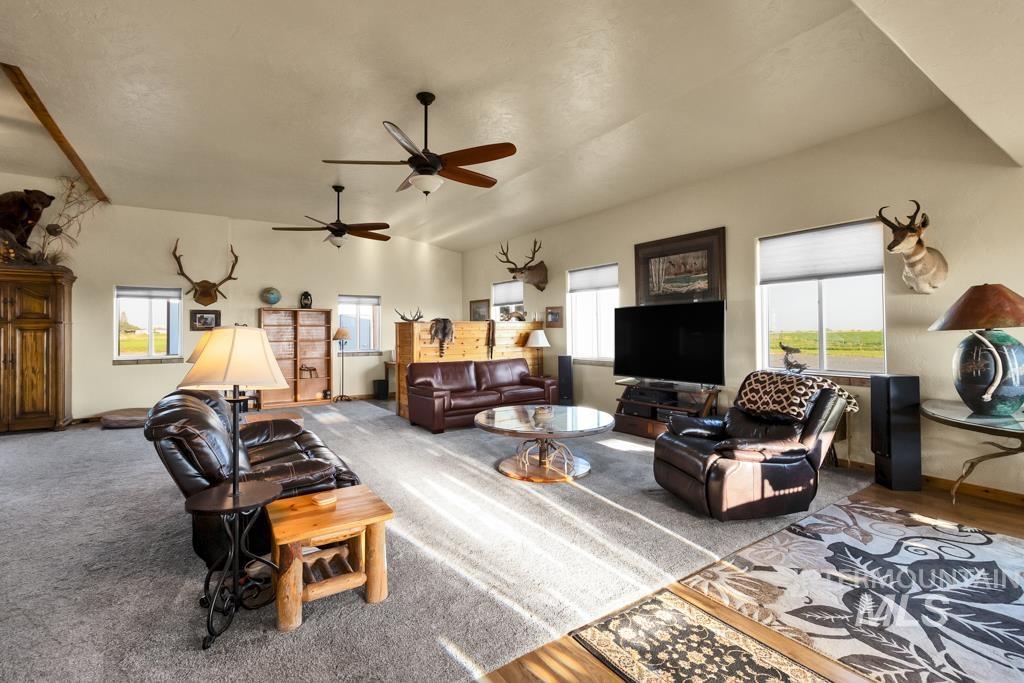 Carpeted living room with vaulted ceiling and baseboards