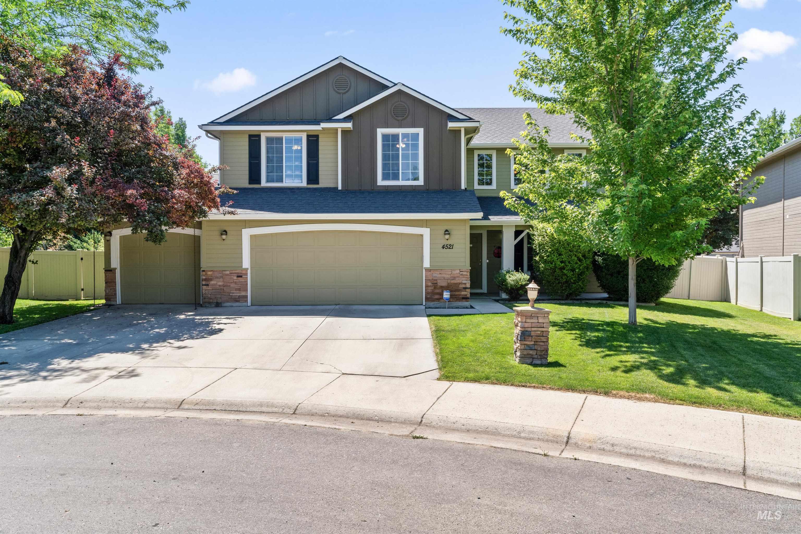 View of front of house with board and batten siding, an attached garage, and driveway