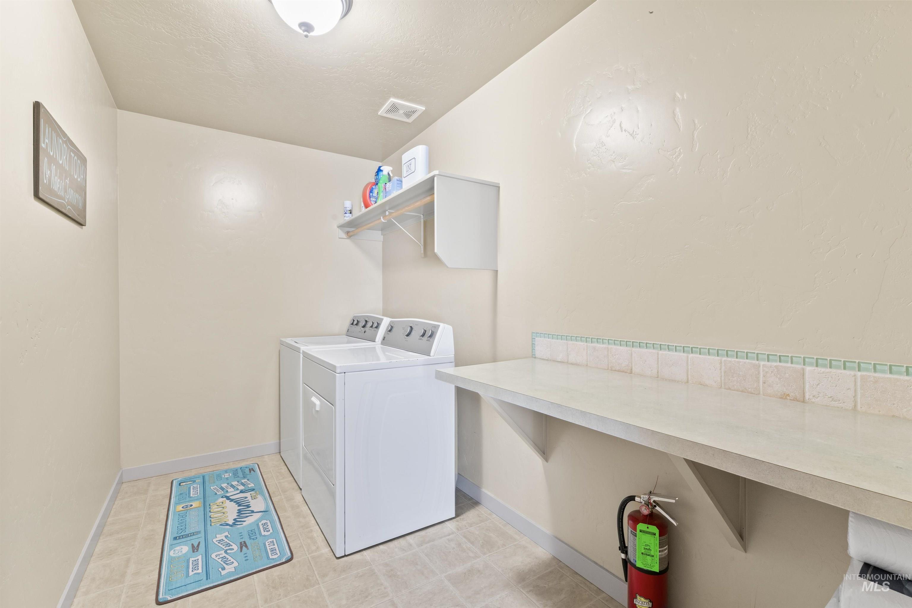 Laundry area with washer and dryer and baseboards