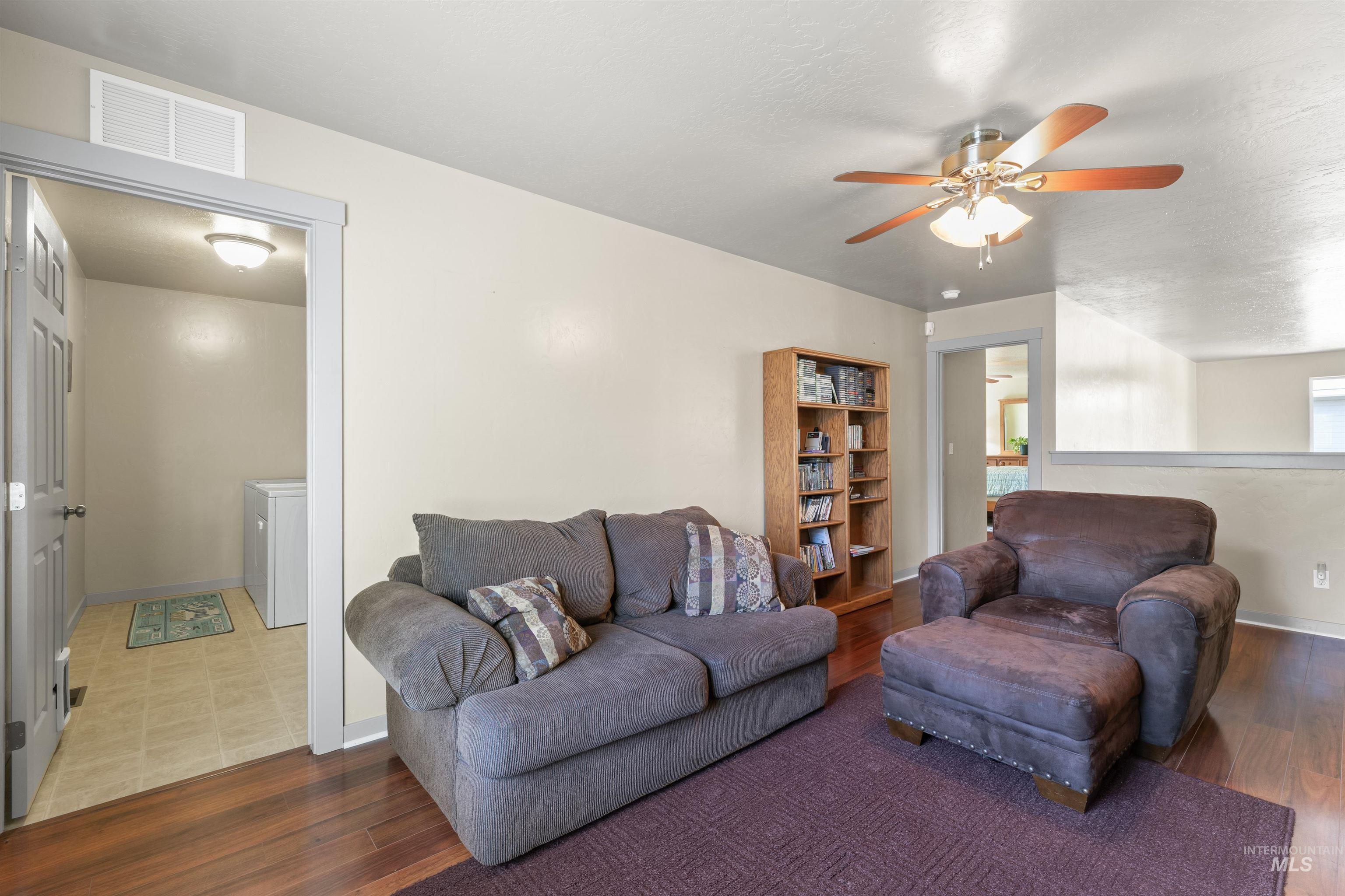 Living area with wood finished floors and ceiling fan