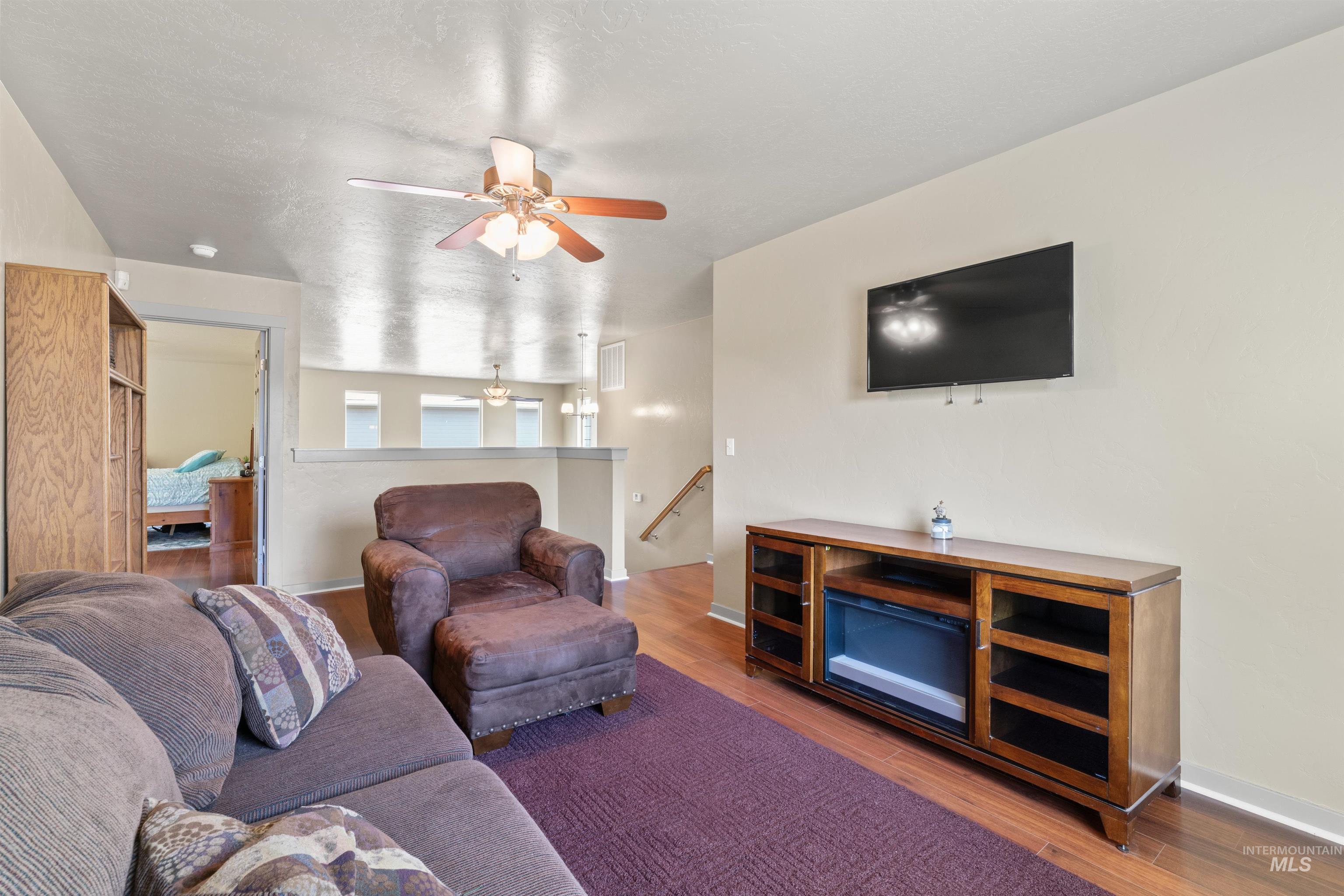 Living area featuring ceiling fan and wood finished floors