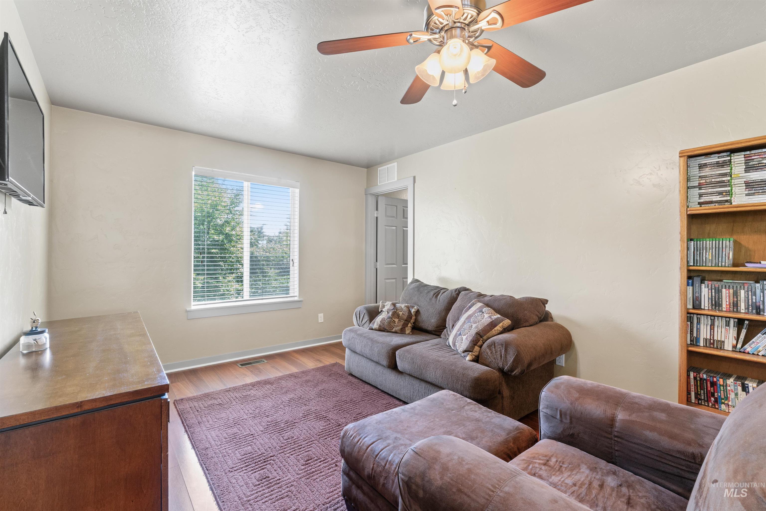 Living room with wood finished floors and a ceiling fan