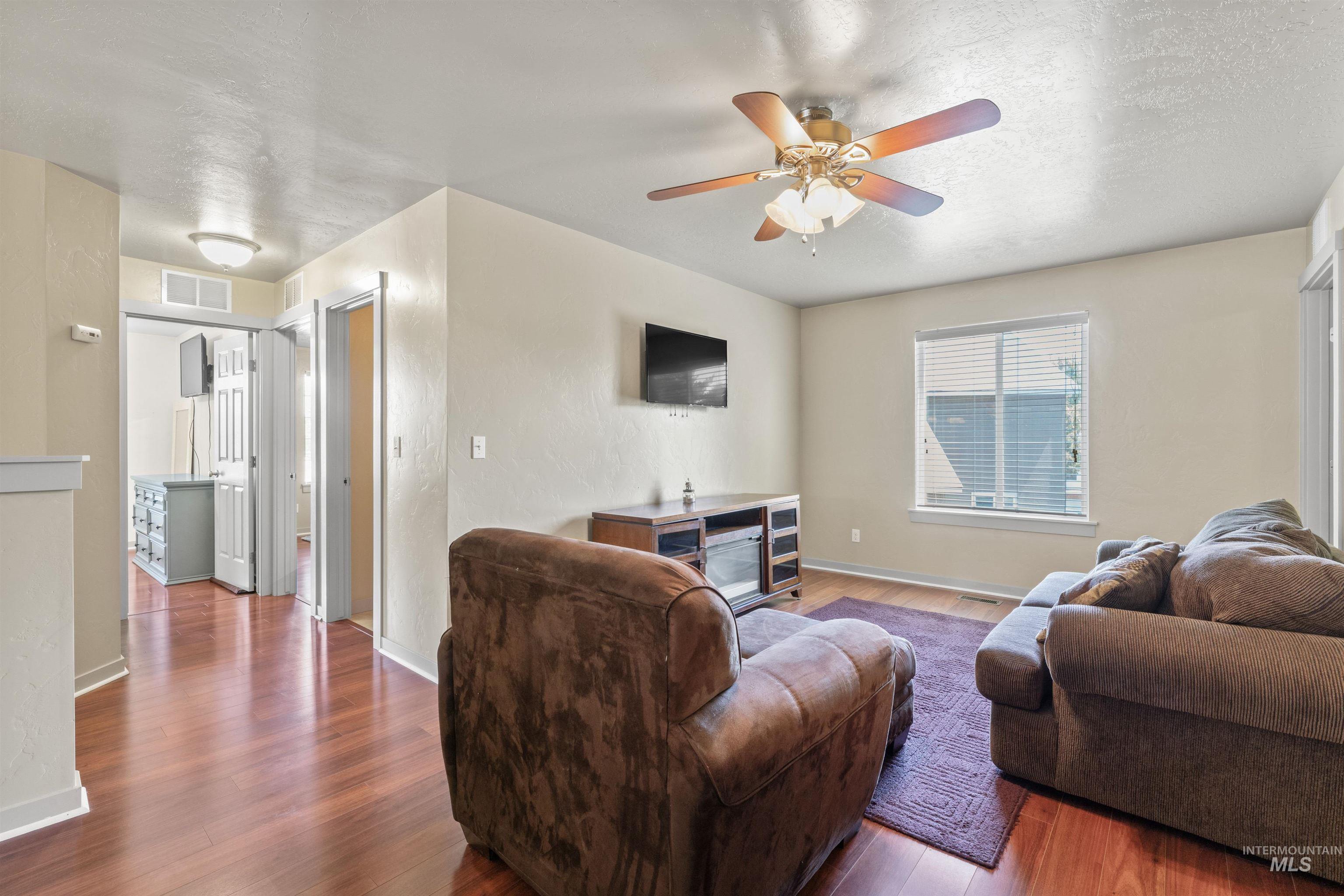 Living area featuring wood finished floors and ceiling fan