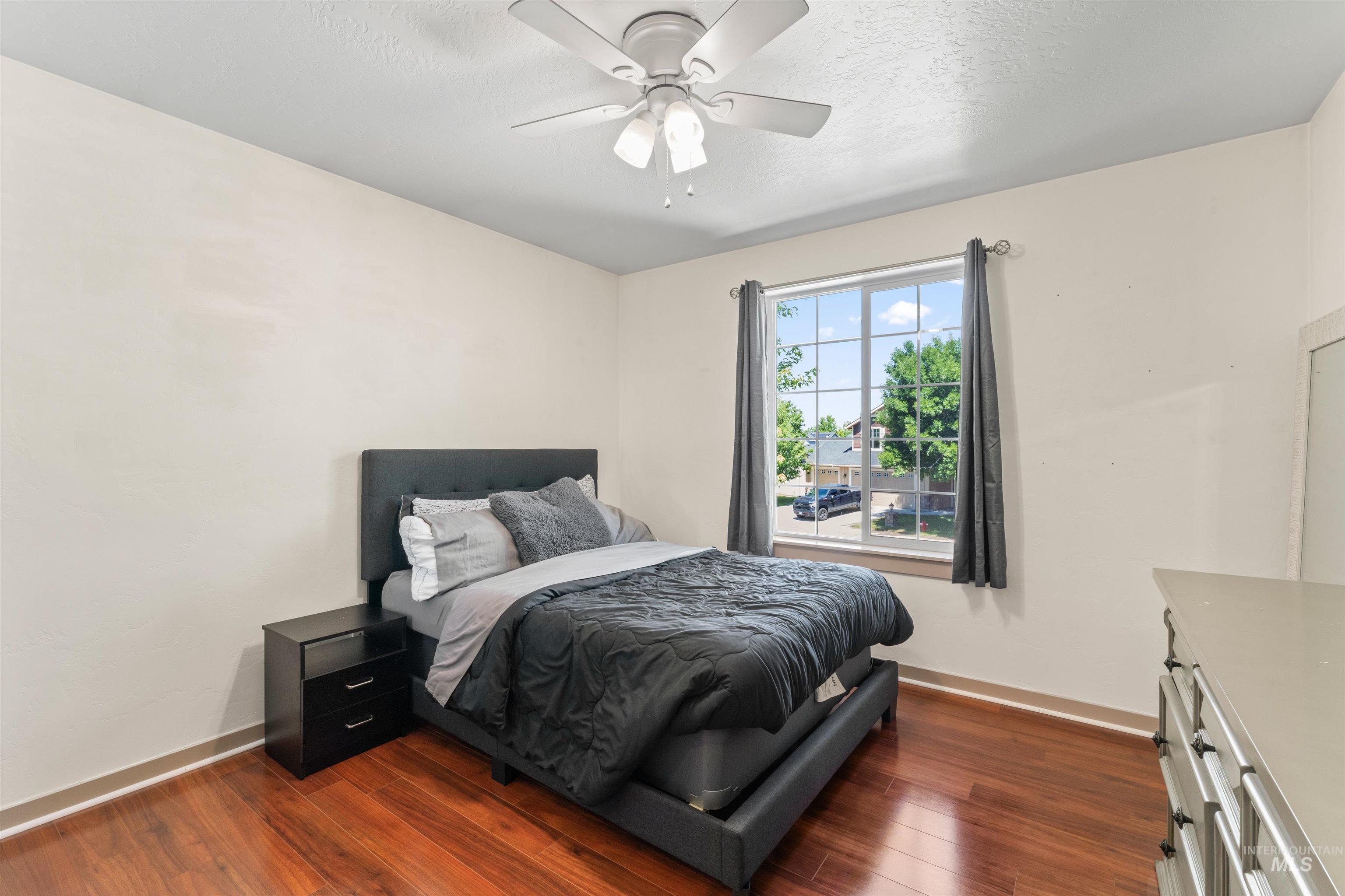 Bedroom featuring dark wood-style floors and a ceiling fan