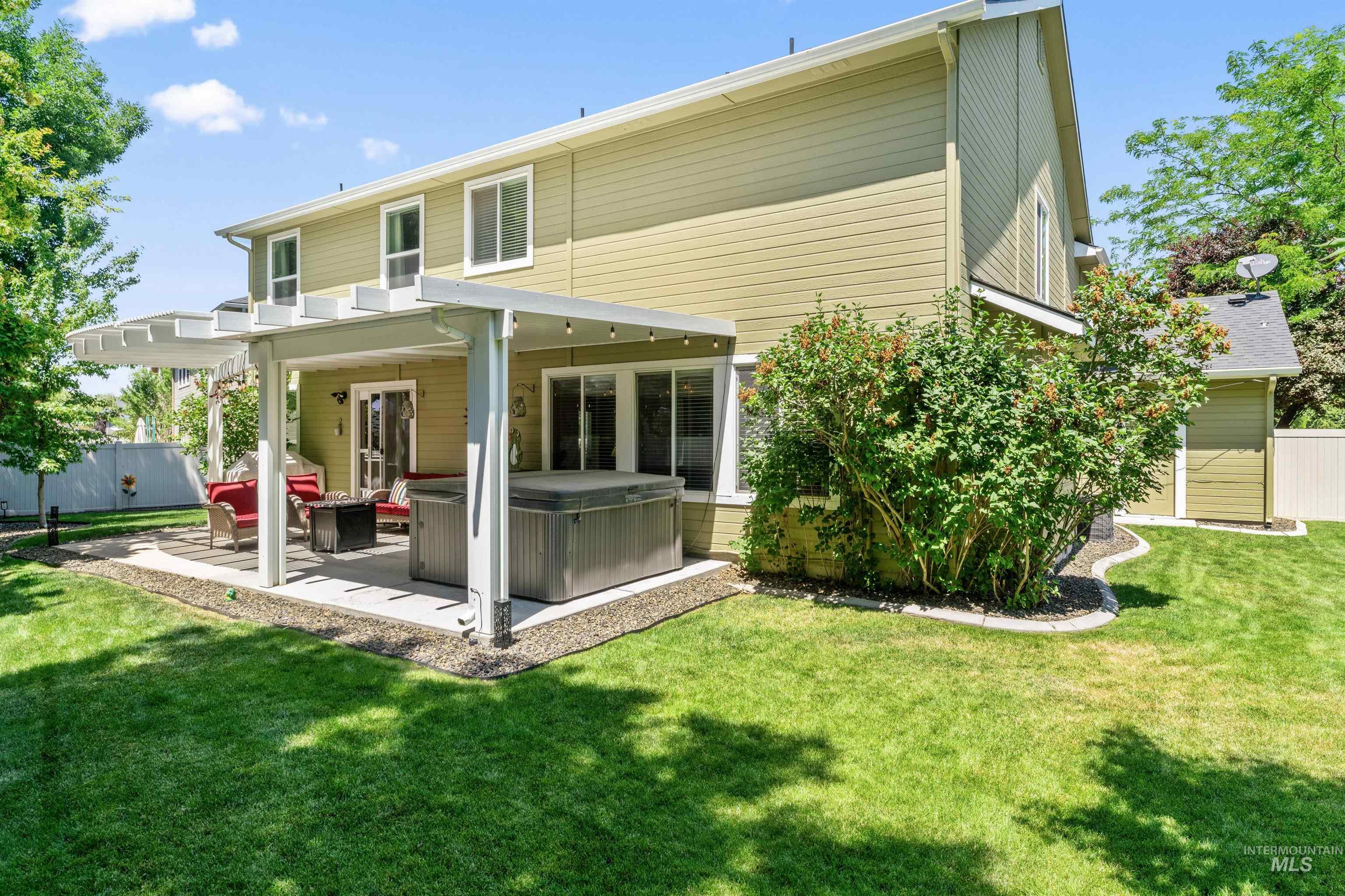 Rear view of house with a patio and a hot tub