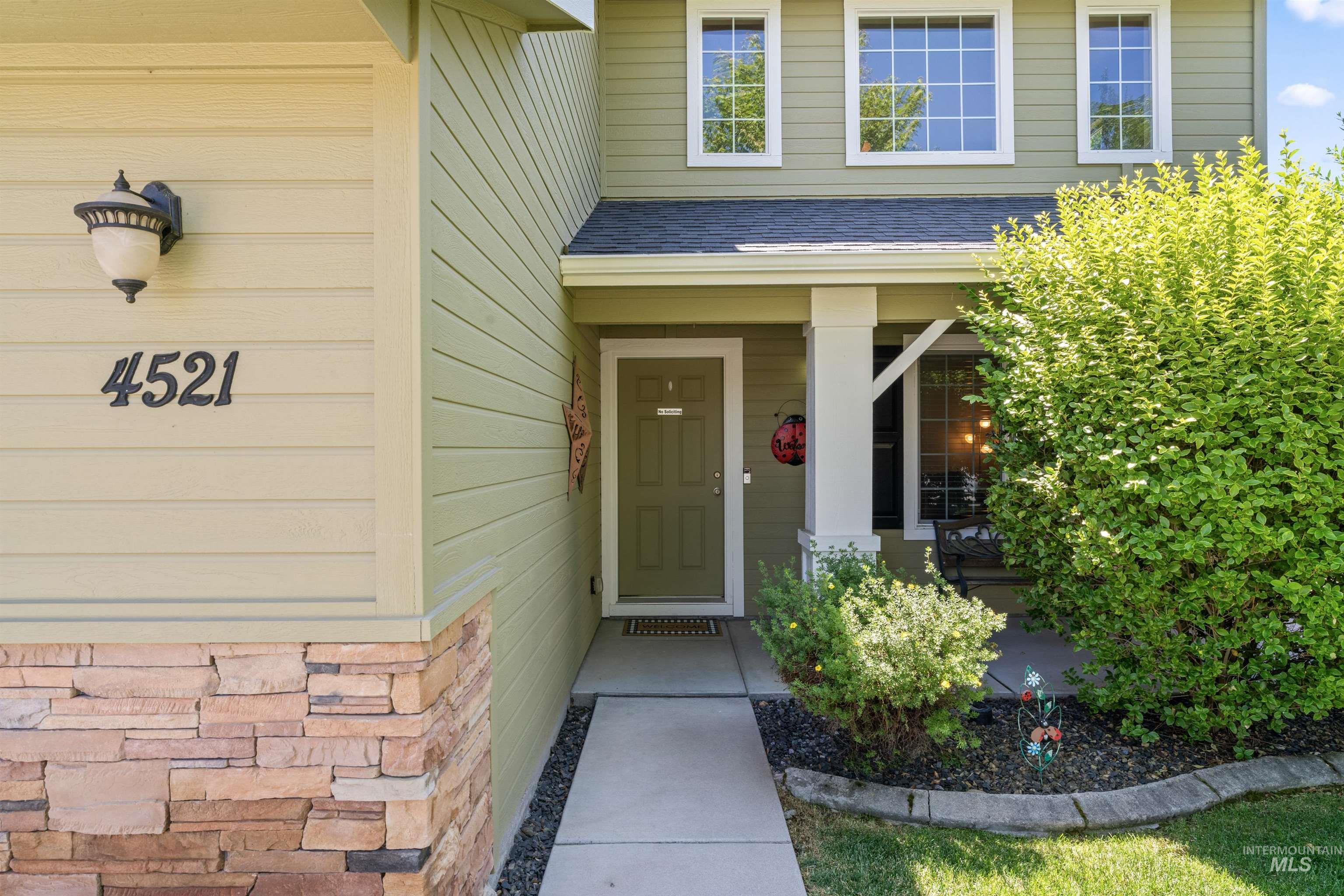 Property entrance with a shingled roof and covered porch
