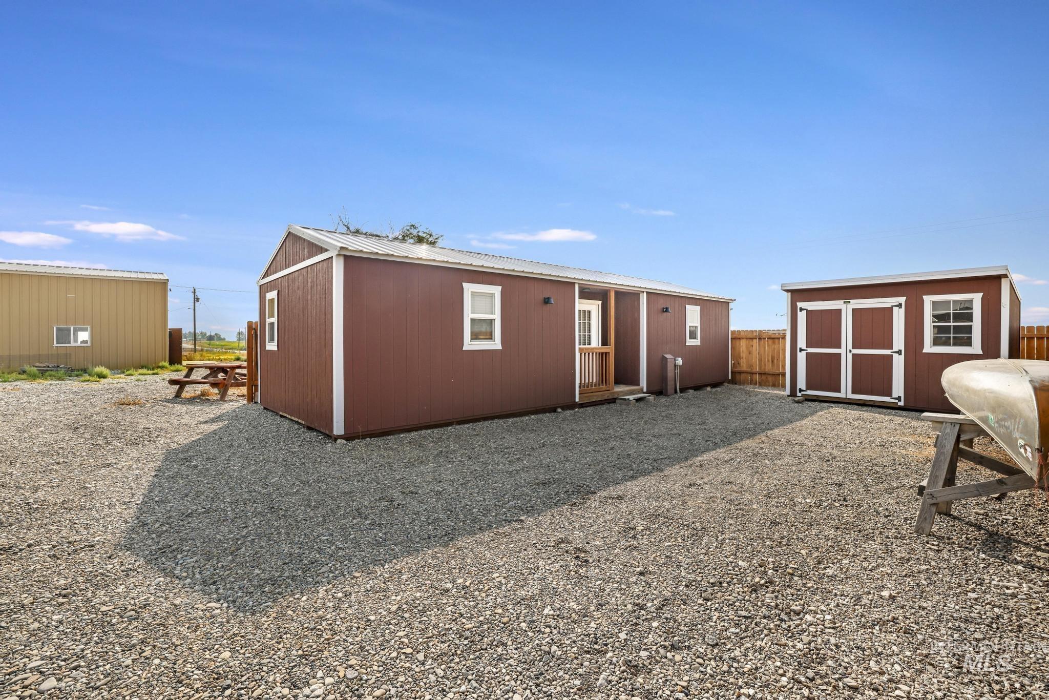 Rear view of property featuring a storage shed