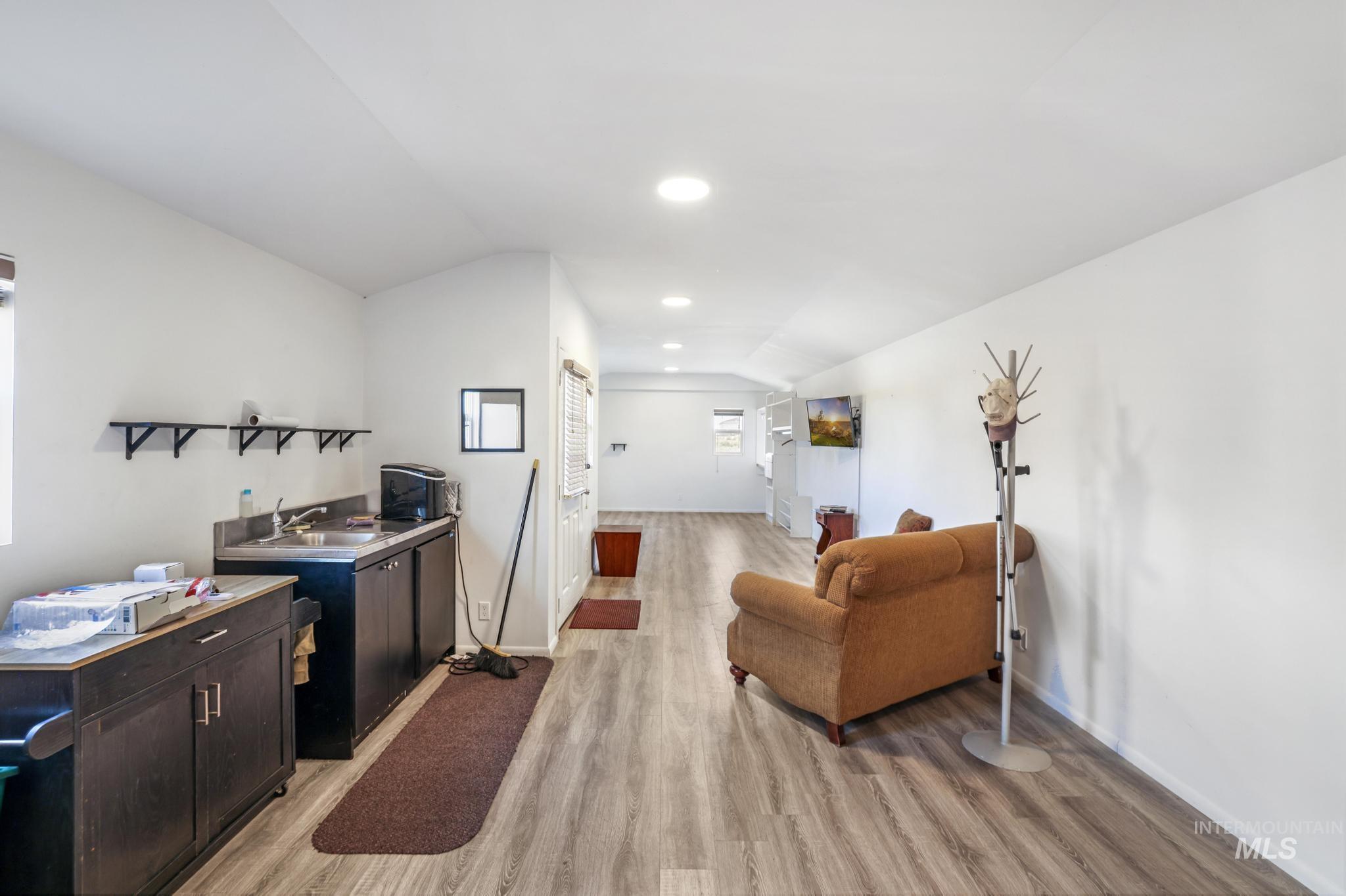 Living room featuring light wood-type flooring, lofted ceiling, and recessed lighting