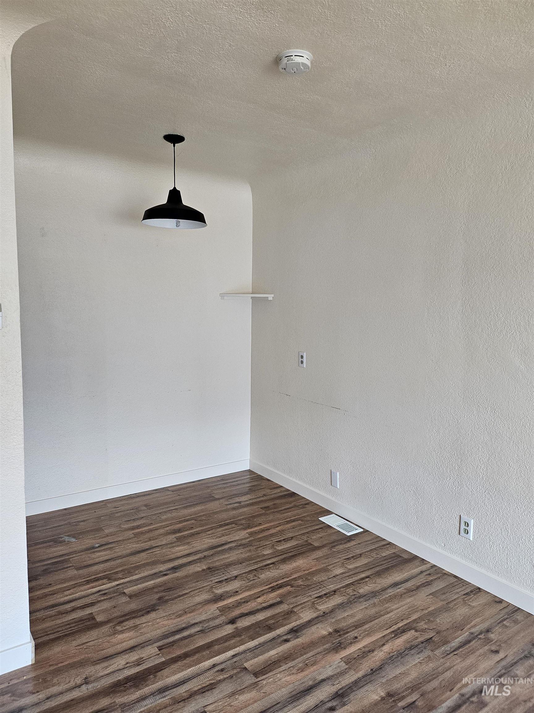 Unfurnished room with dark wood-style floors and a textured ceiling