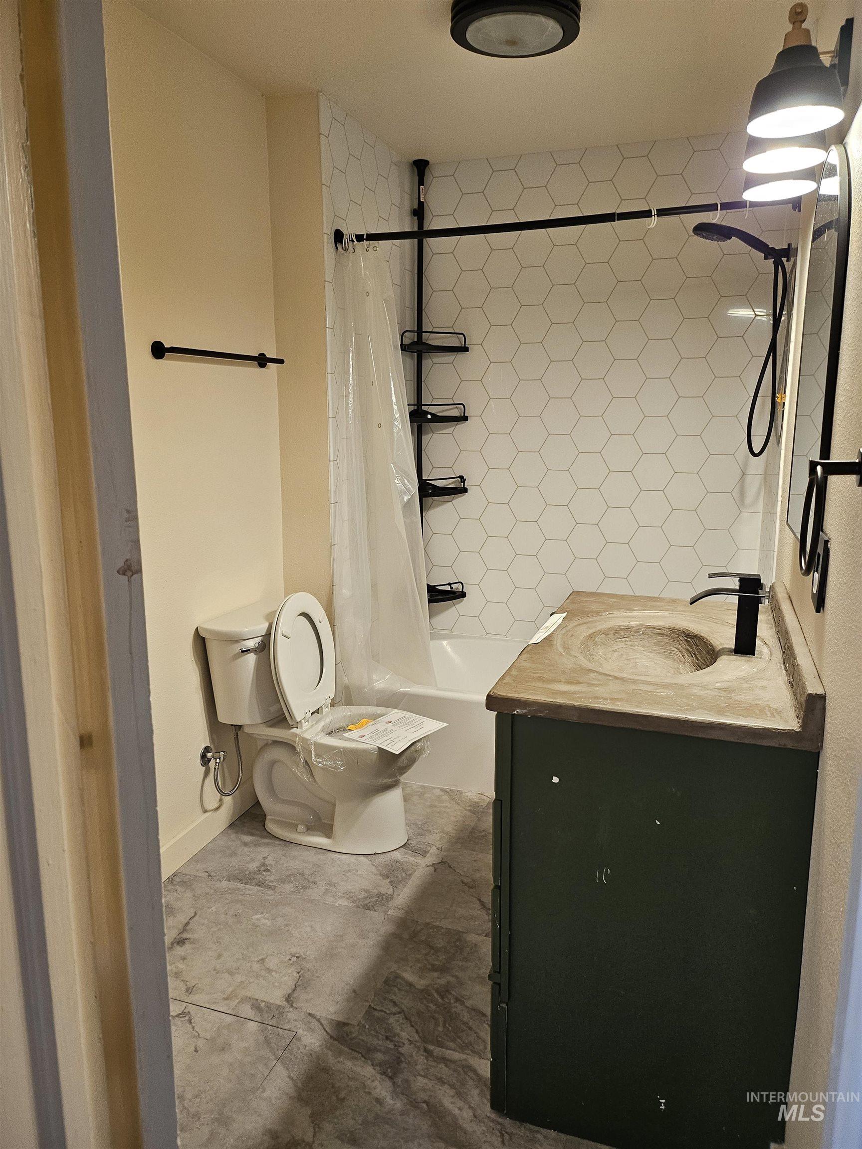 Bathroom with vanity and shower / bathtub combination with curtain