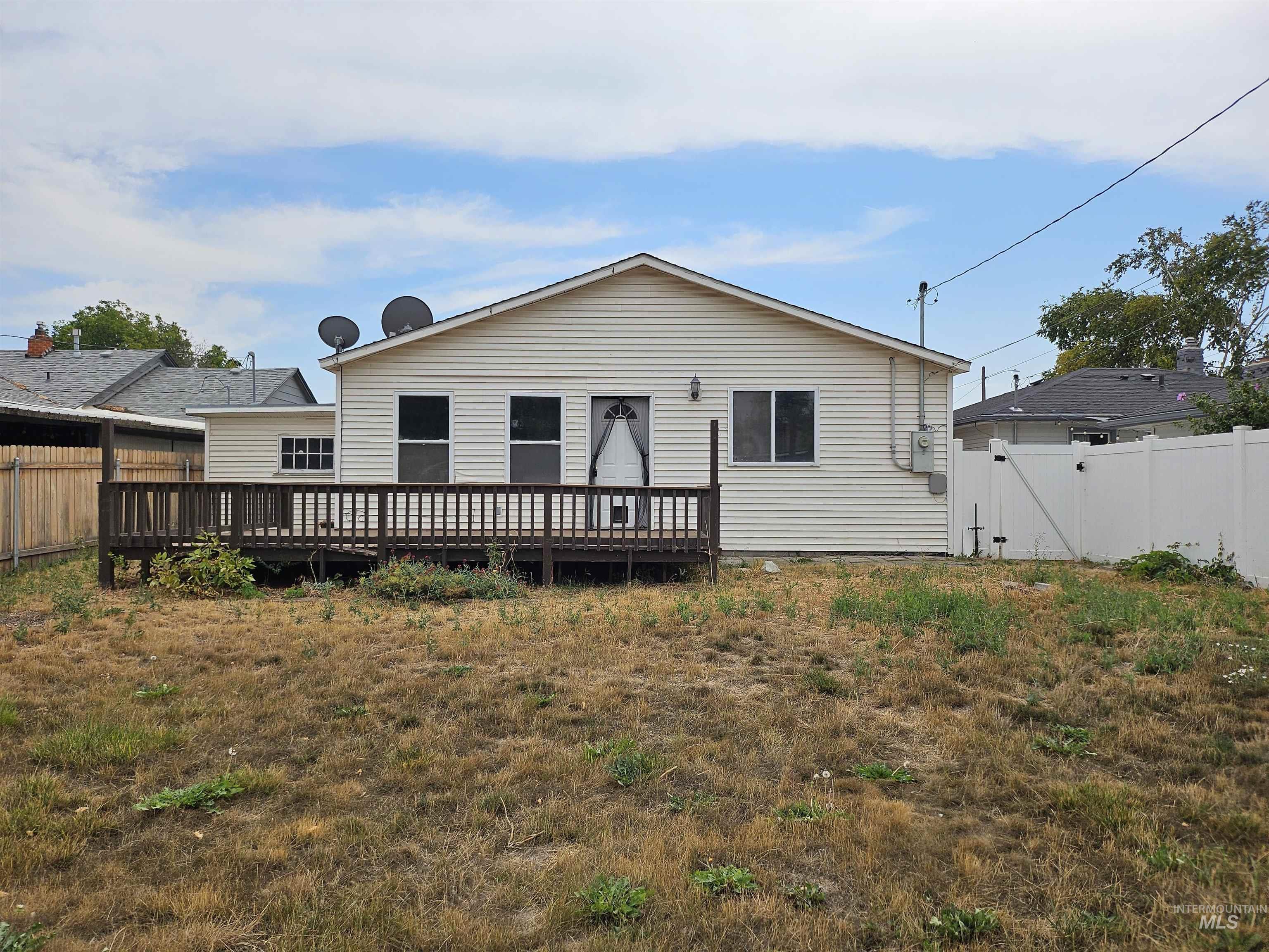 Back of property with a deck and a gate