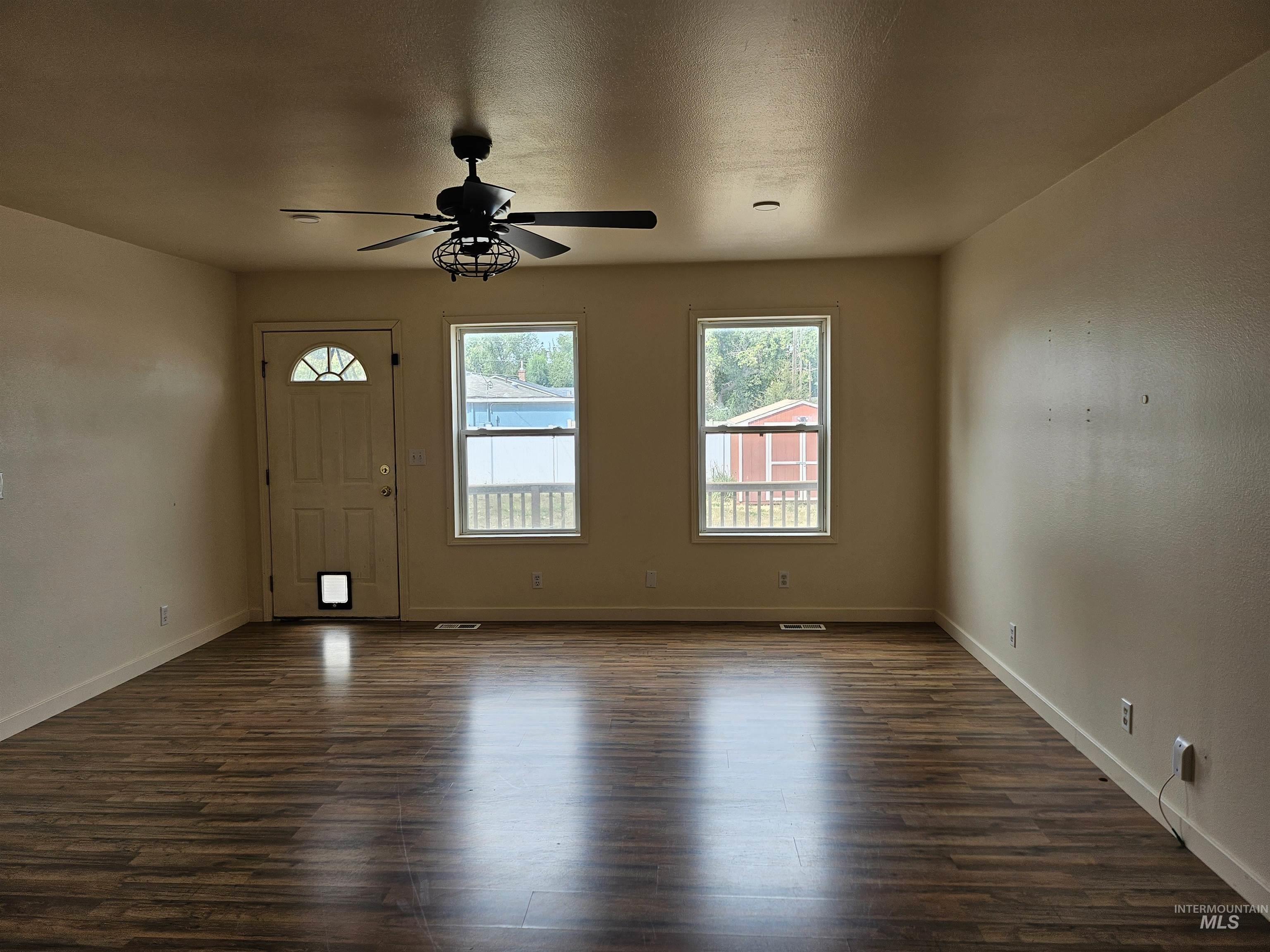 Entrance foyer featuring dark wood-style floors, ceiling fan, and a textured ceiling
