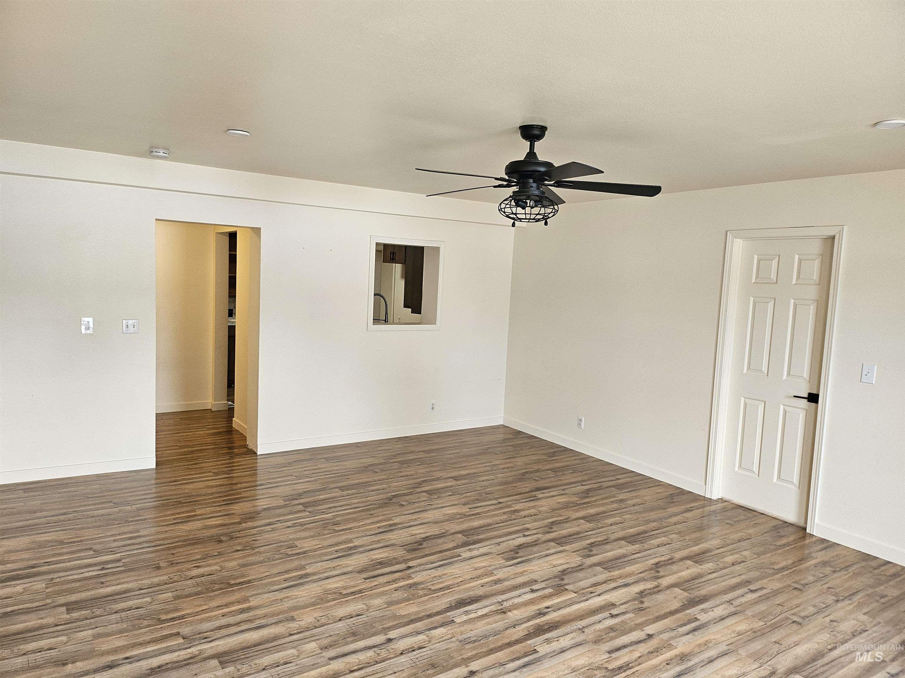 Empty room with wood finished floors and a ceiling fan