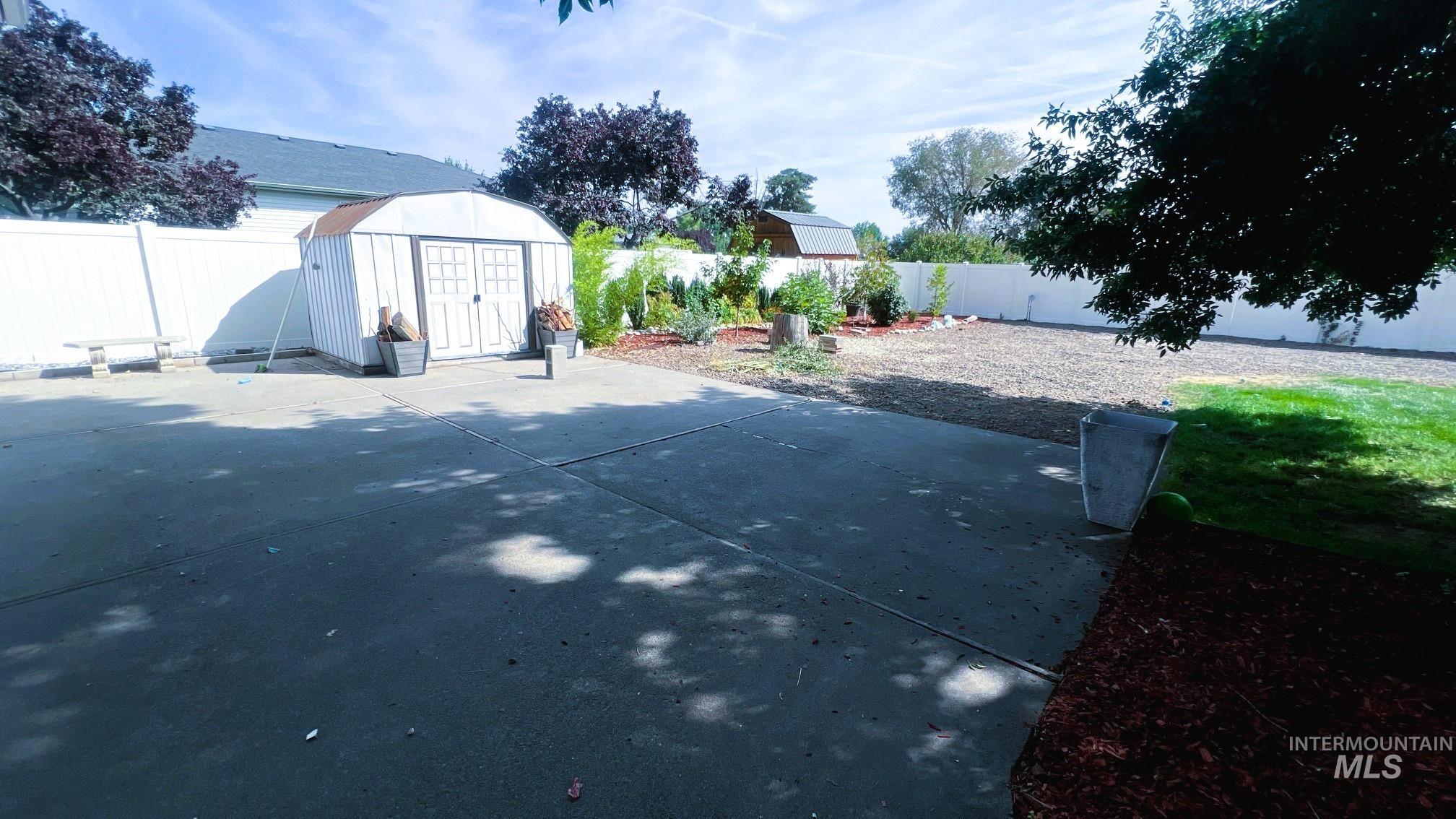 Fenced backyard featuring a shed