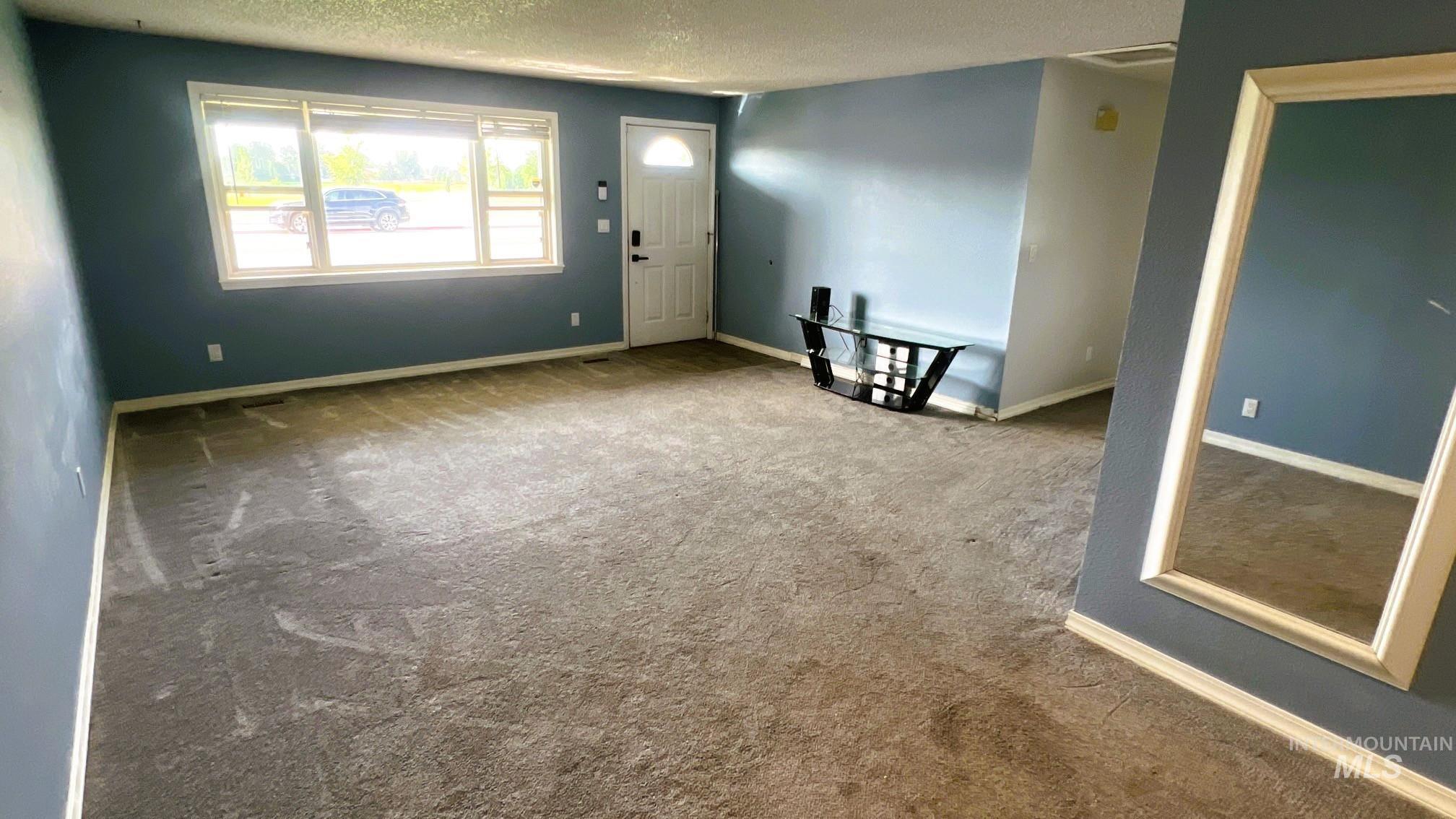 Entryway with carpet and a textured ceiling