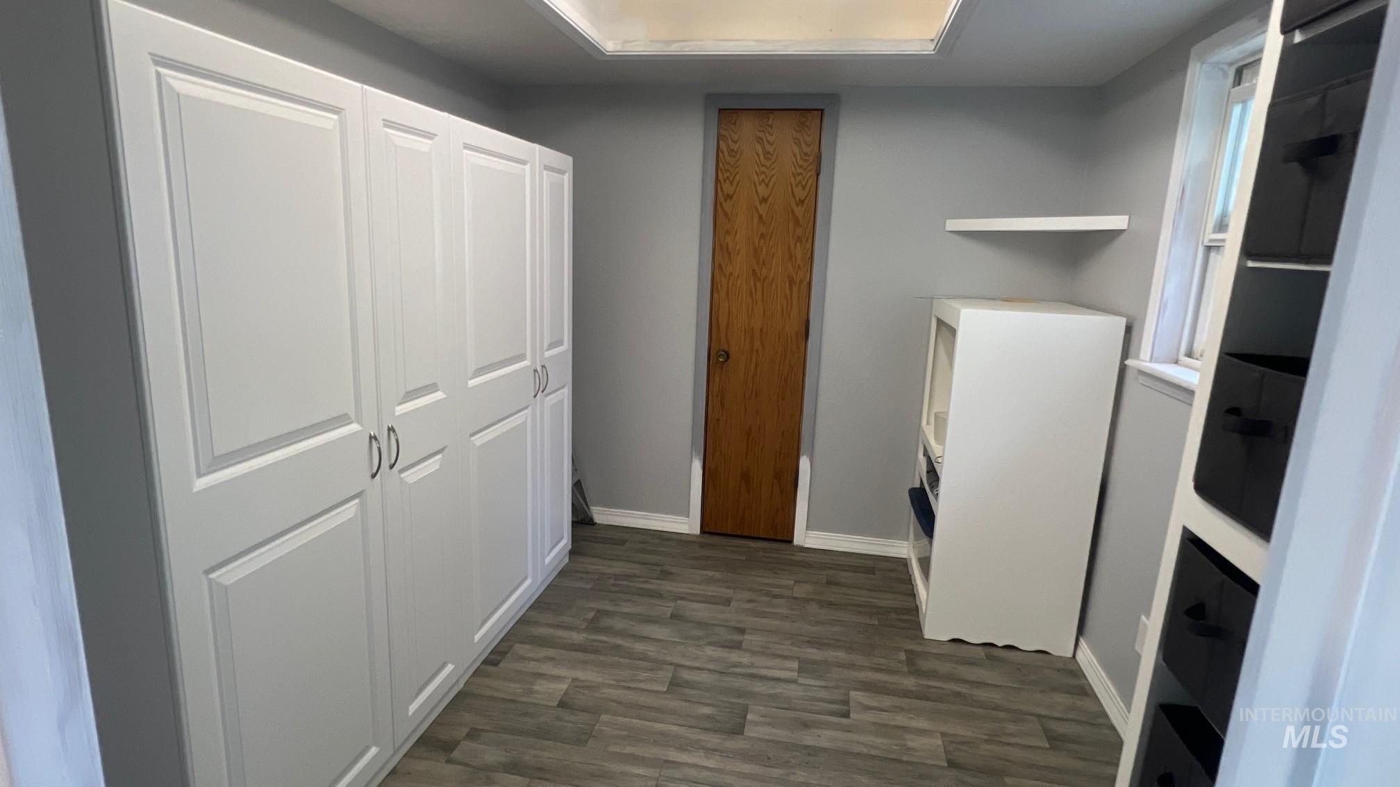 Unfurnished office with dark wood finished floors and baseboards