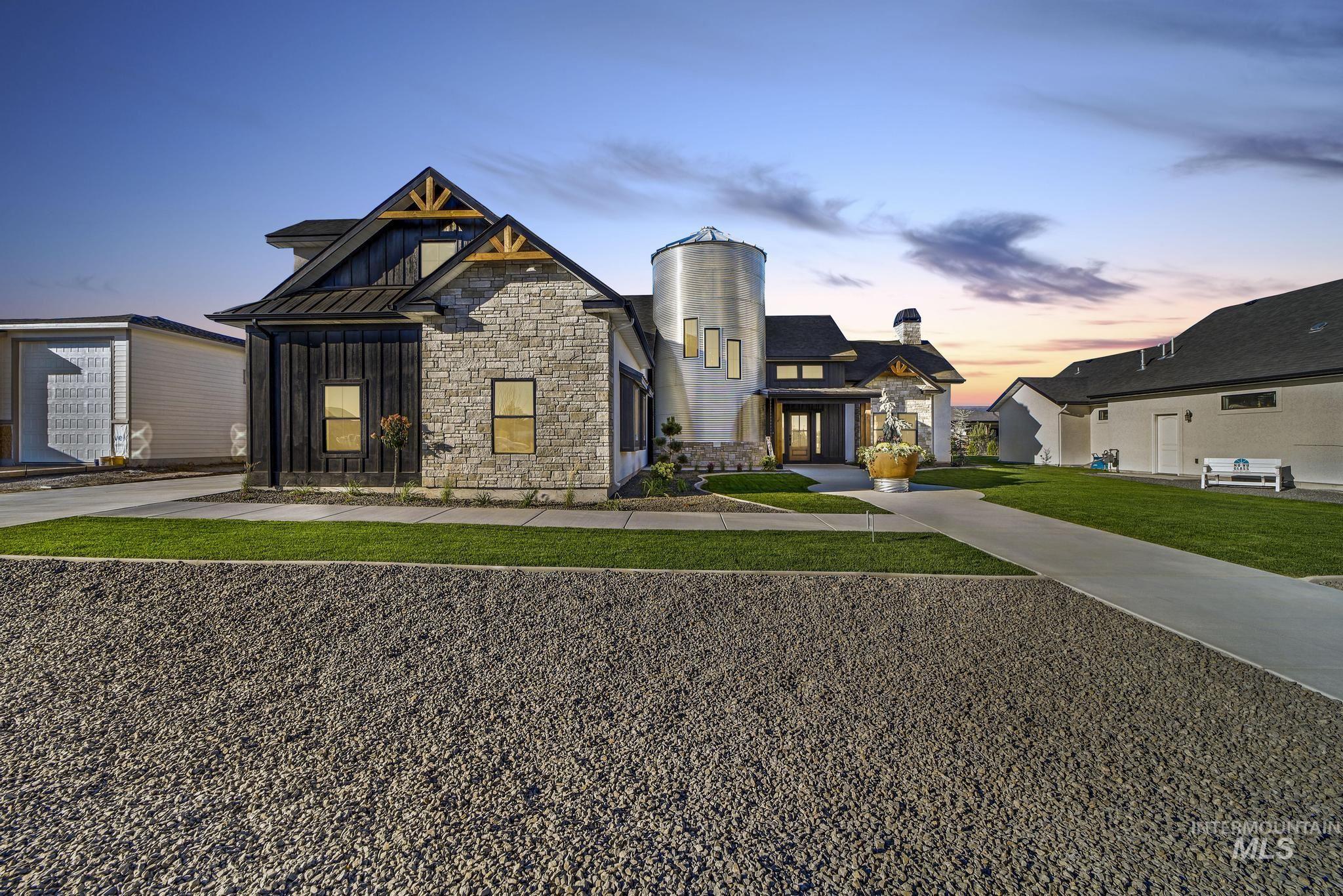 View of front of house featuring stone siding, board and batten siding, a standing seam roof, and a metal roof