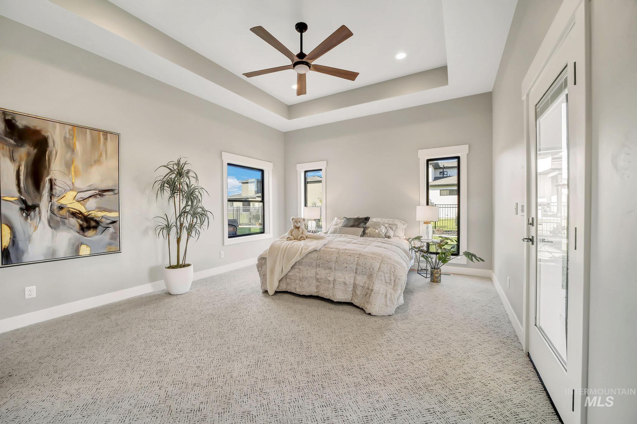 Bedroom with a ceiling fan, a tray ceiling, carpet flooring, and recessed lighting