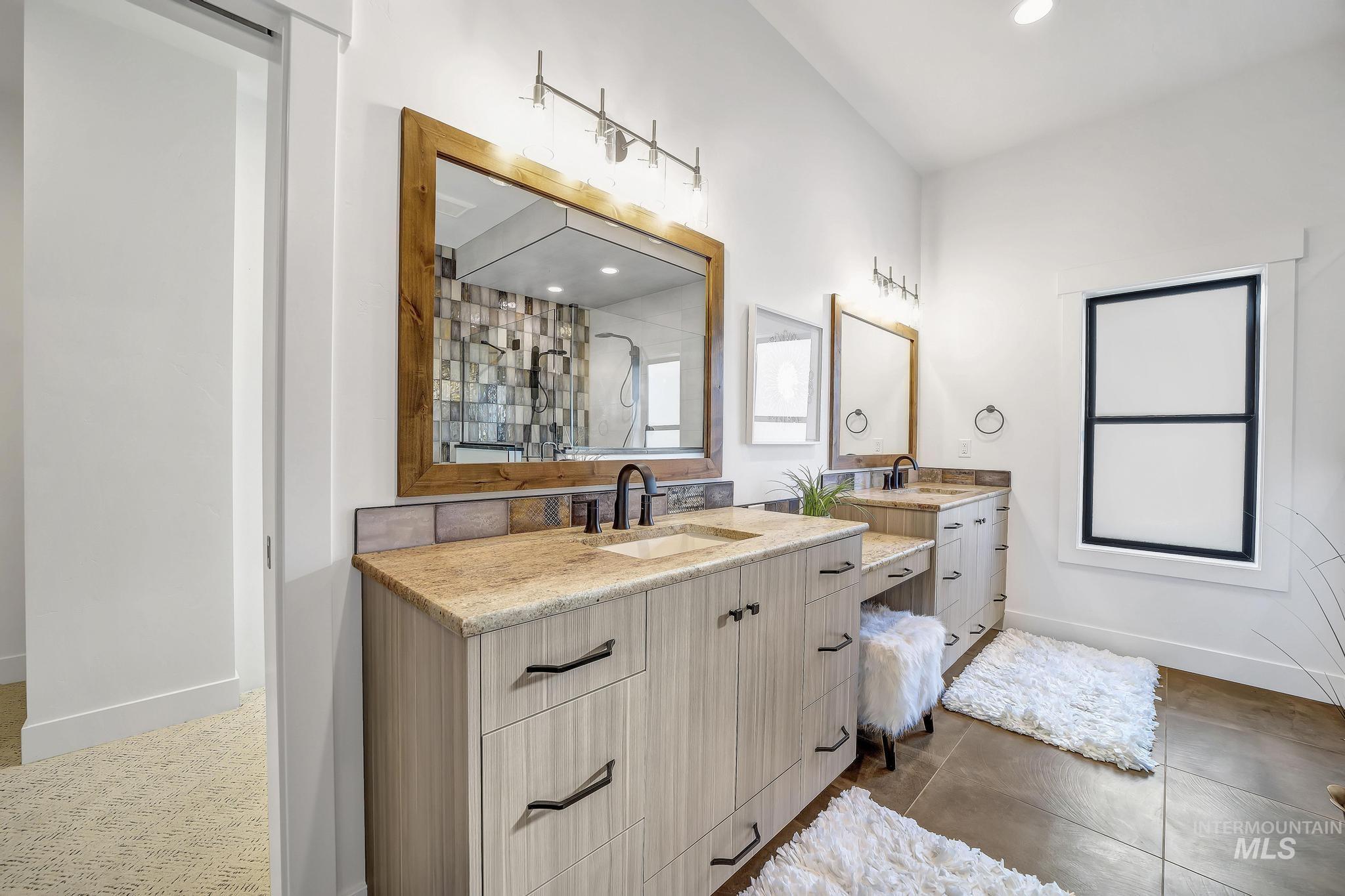 Bathroom with two vanities, recessed lighting, a shower stall, and dark tile patterned flooring