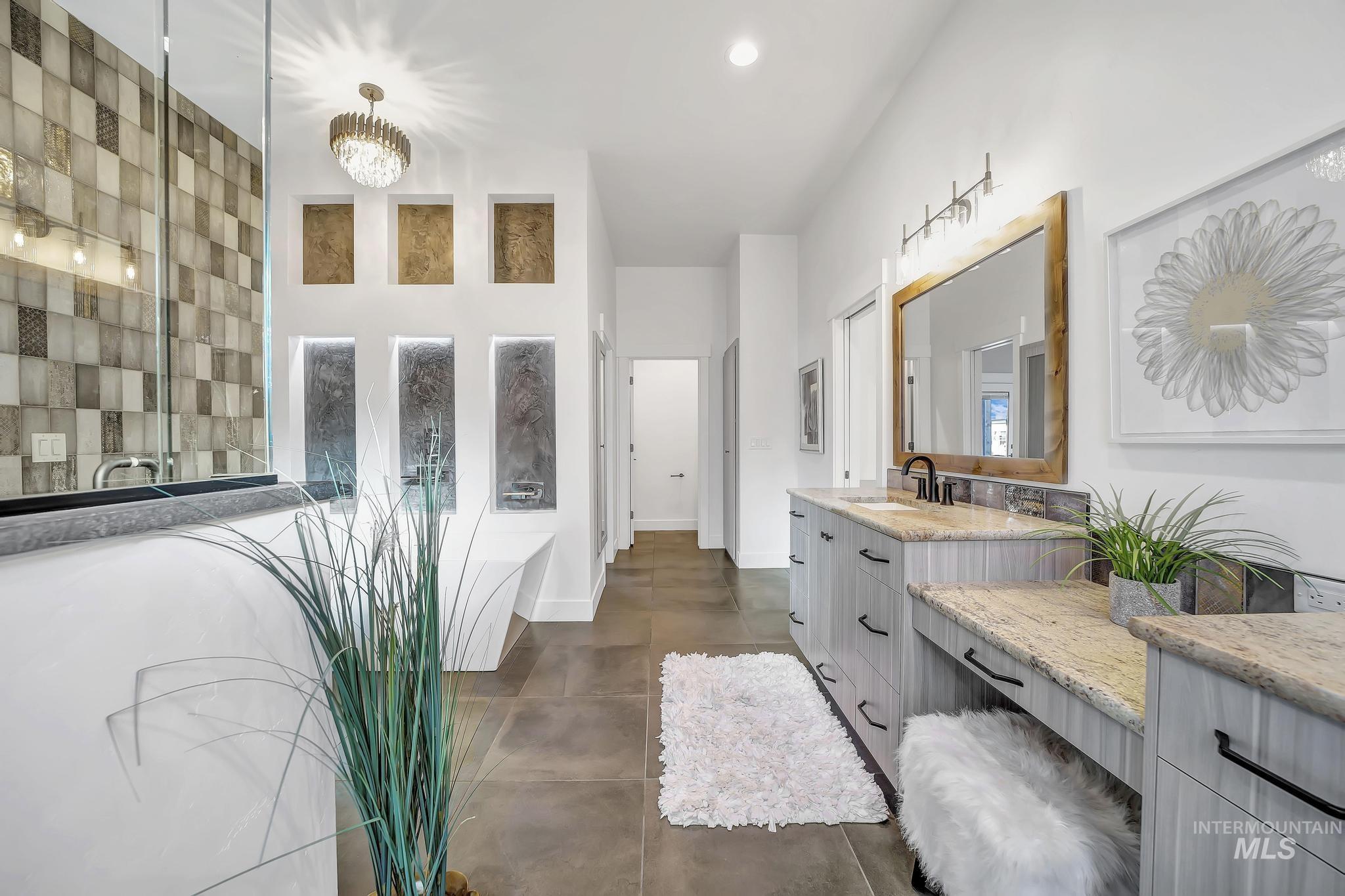Bathroom with a bath, vanity, a chandelier, a tile shower, and recessed lighting