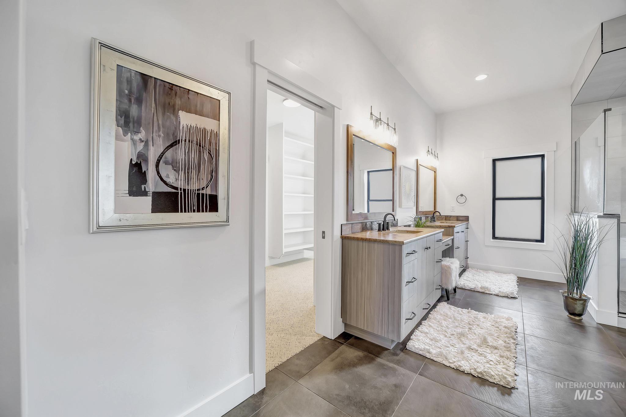 Full bathroom with double vanity, recessed lighting, and dark tile patterned floors
