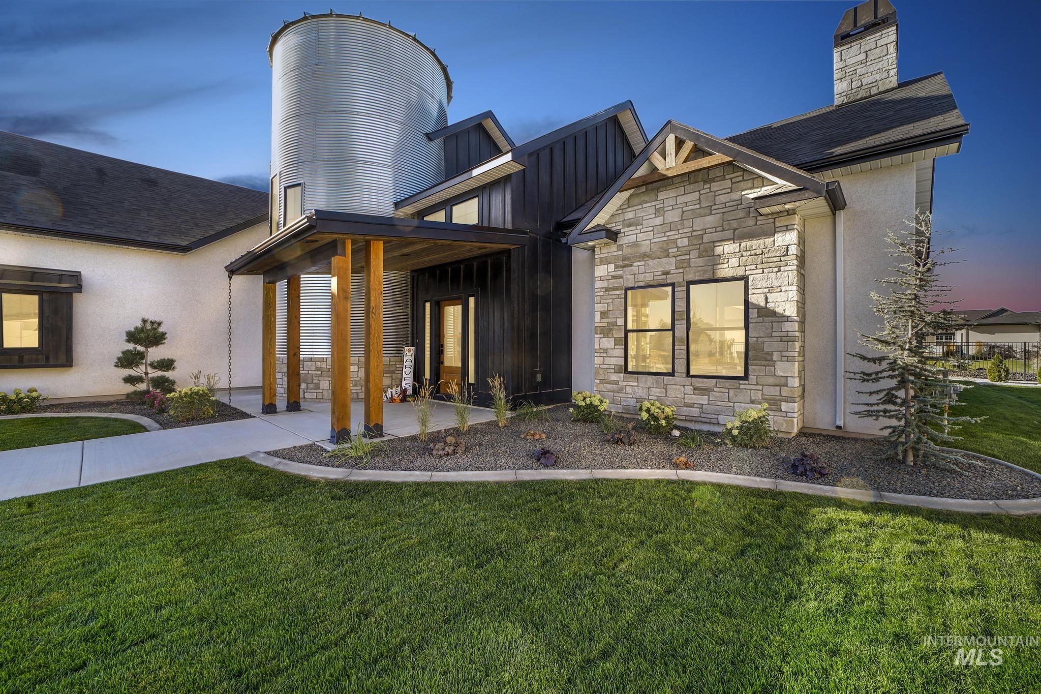 View of front of home featuring stone siding, a front lawn, a chimney, and board and batten siding