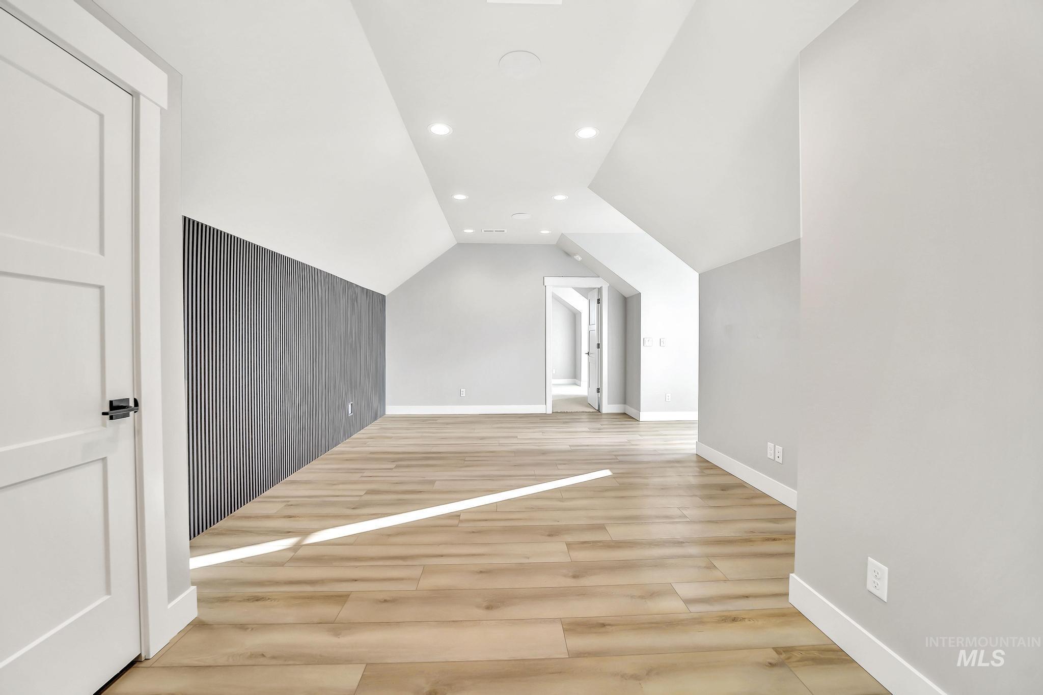 Additional living space featuring recessed lighting, lofted ceiling, and light wood-type flooring