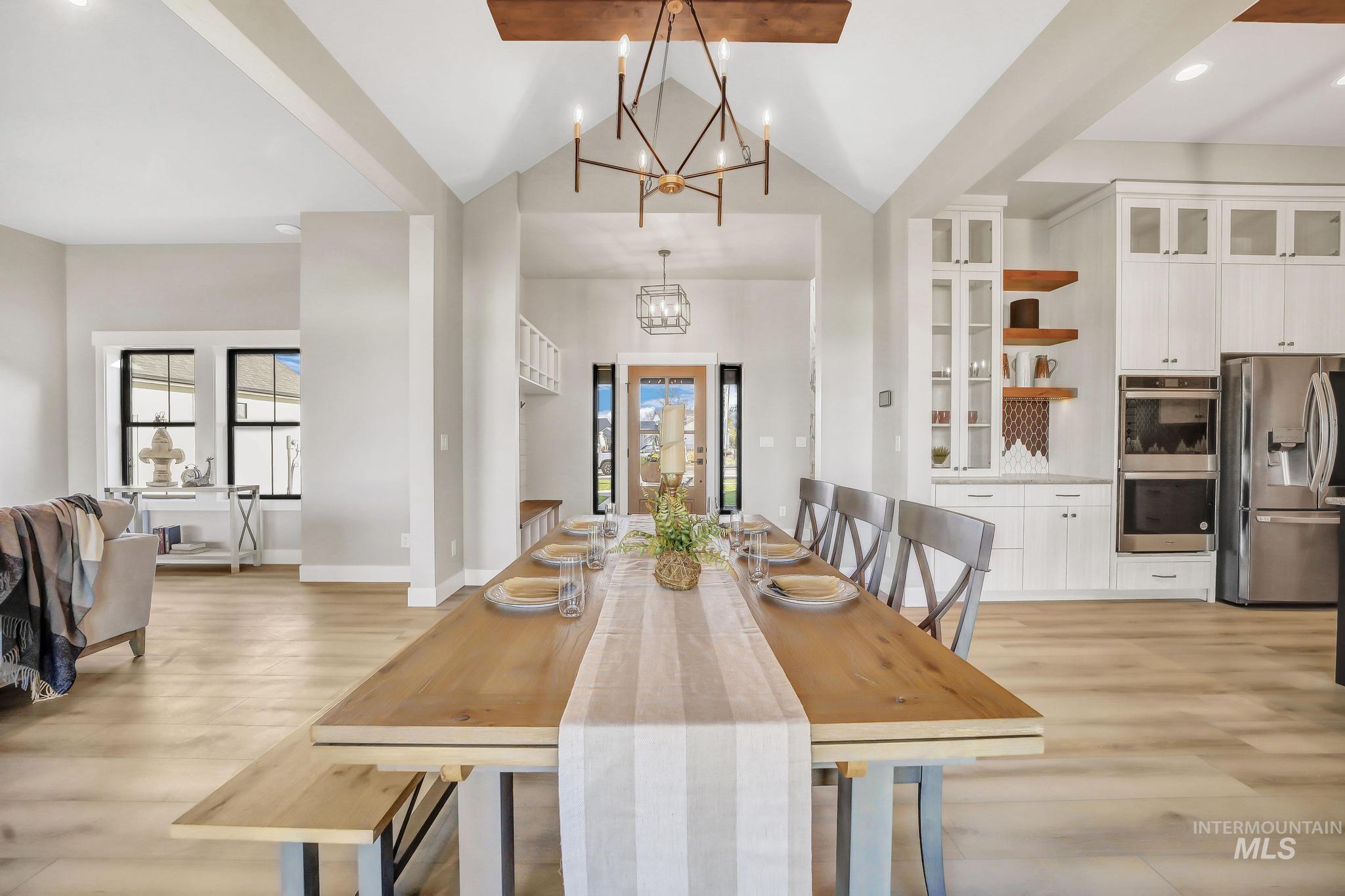 Dining area featuring light wood finished floors, recessed lighting, a chandelier, and vaulted ceiling