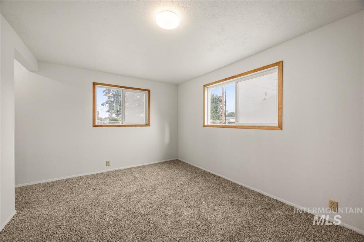 Carpeted empty room with baseboards