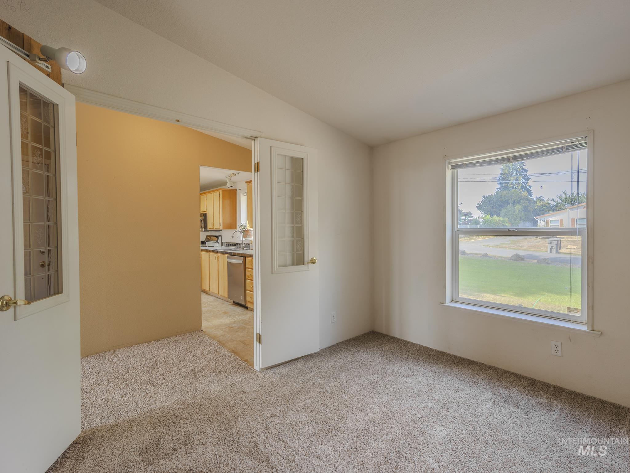 Spare room with lofted ceiling and light colored carpet