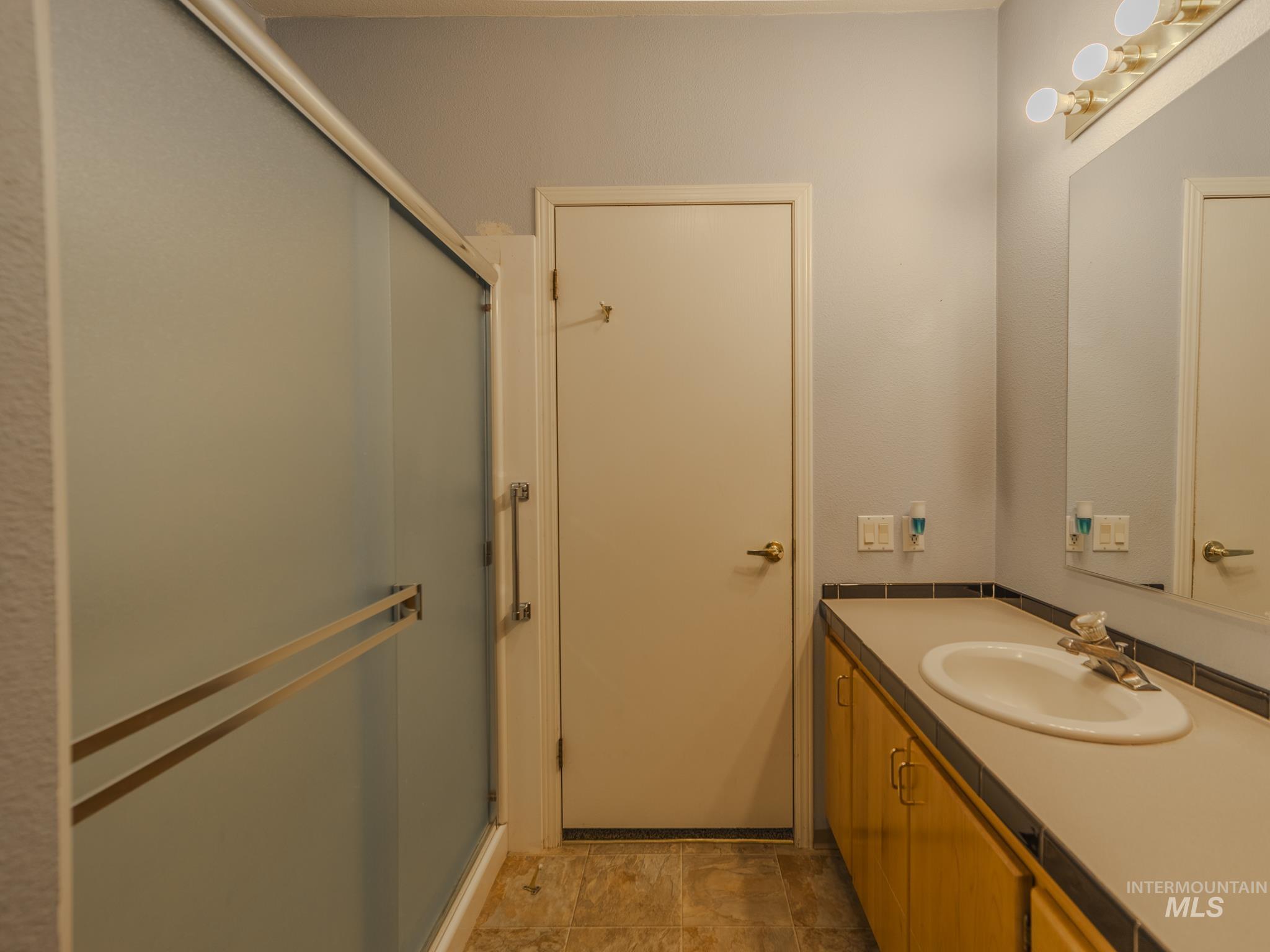 Full bathroom with vanity and a stall shower