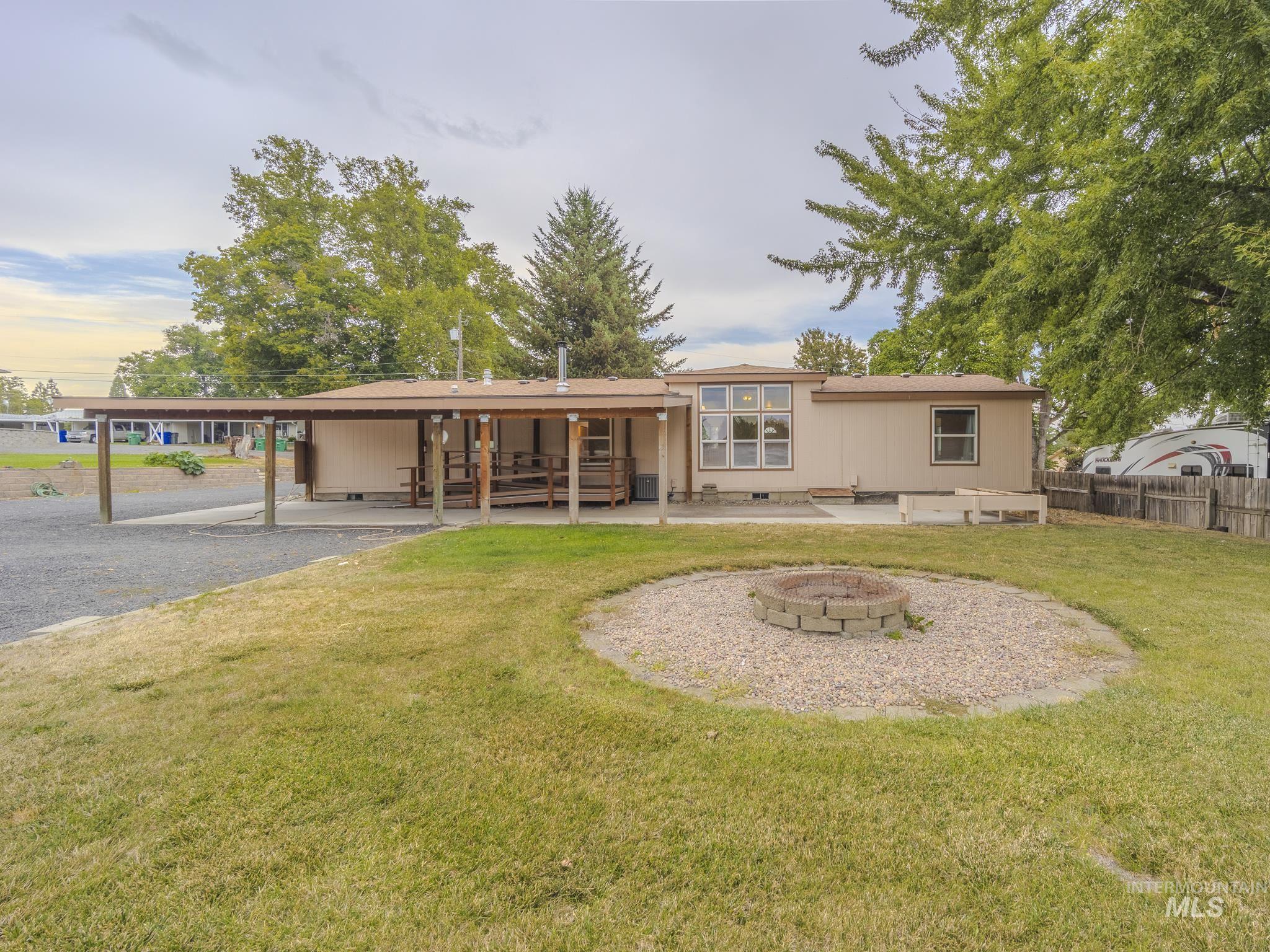 Rear view of house featuring a patio, an outdoor fire pit, and crawl space