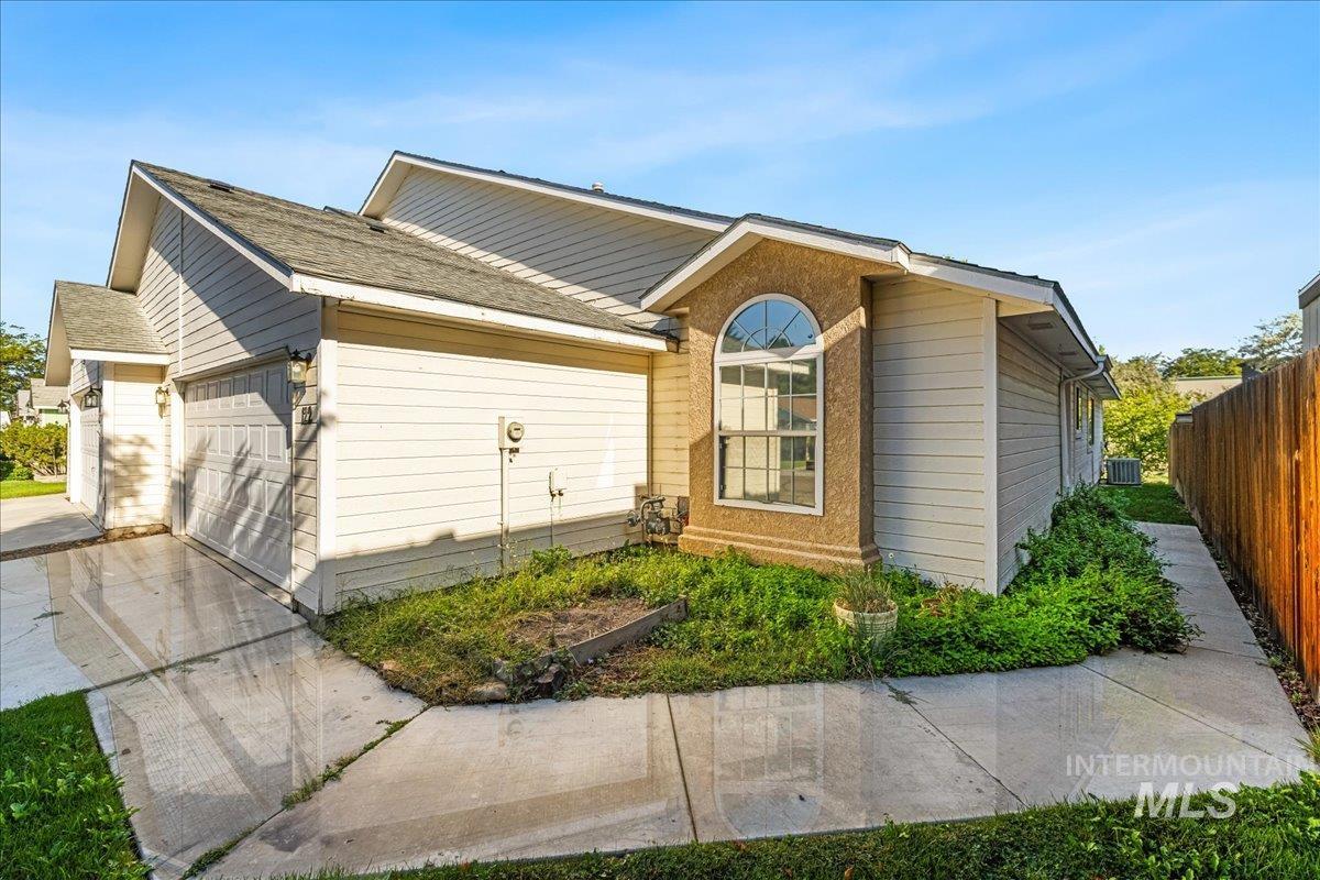View of front facade featuring roof with shingles, concrete driveway, and a garage