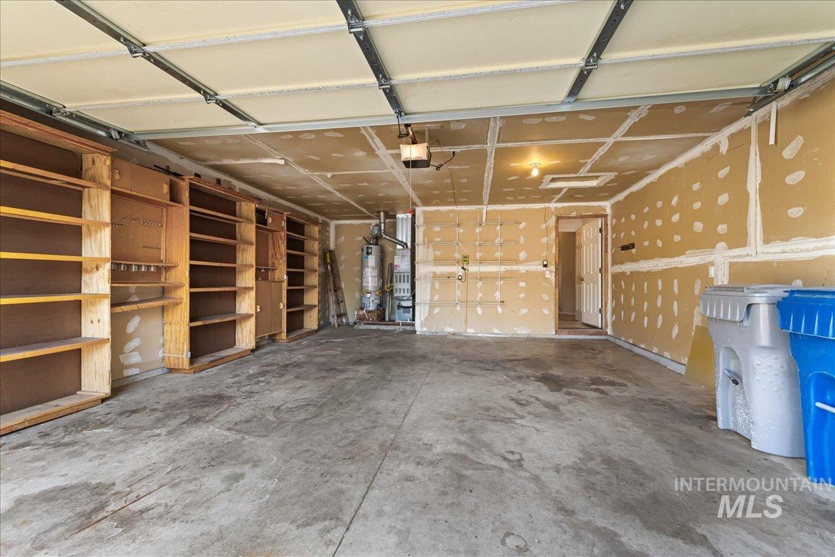 Garage featuring water heater and a garage door opener
