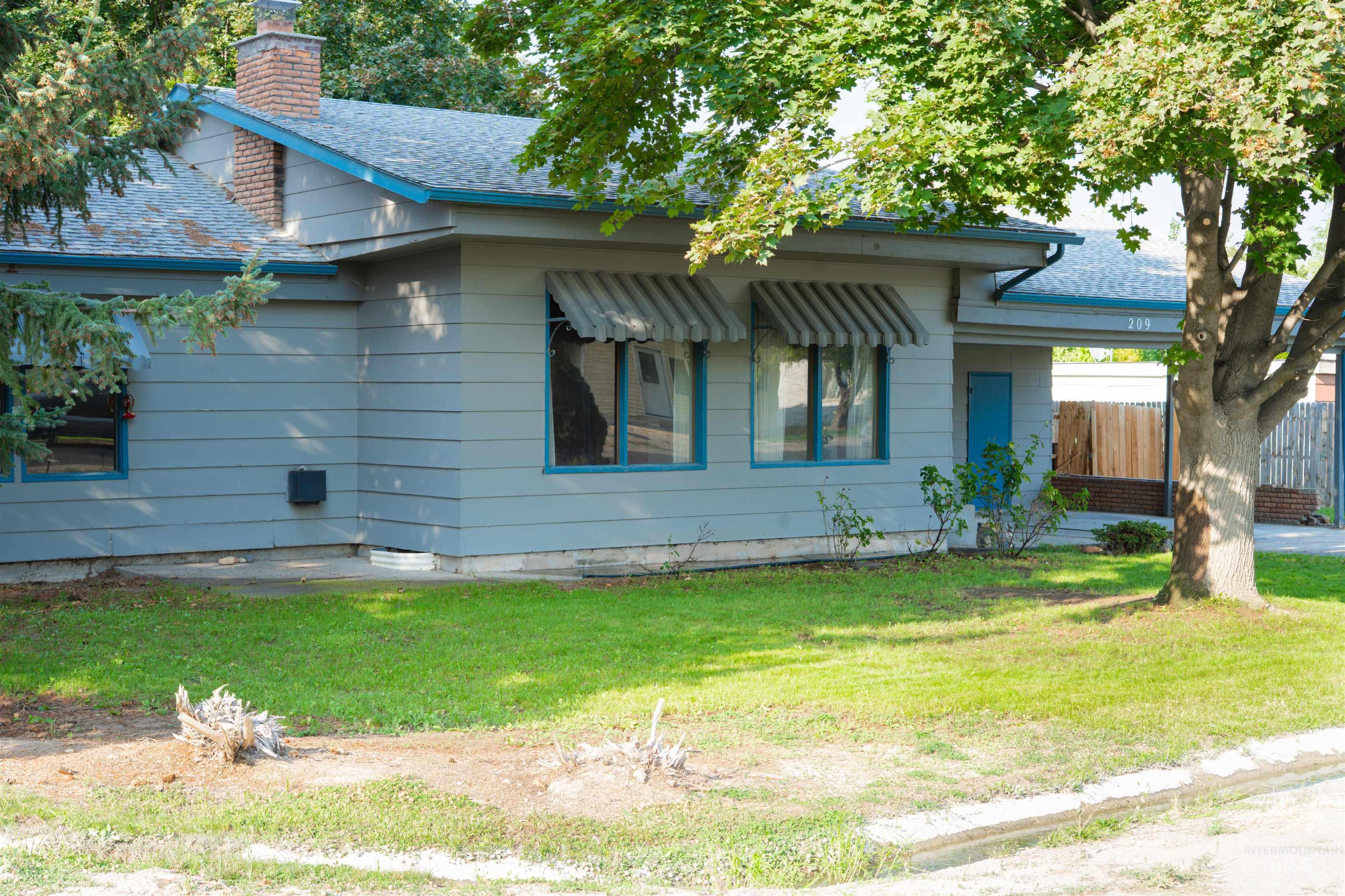 View of front facade with a shingled roof and a chimney