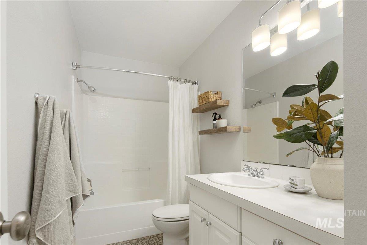 Bathroom featuring shower / bath combo with shower curtain and vanity