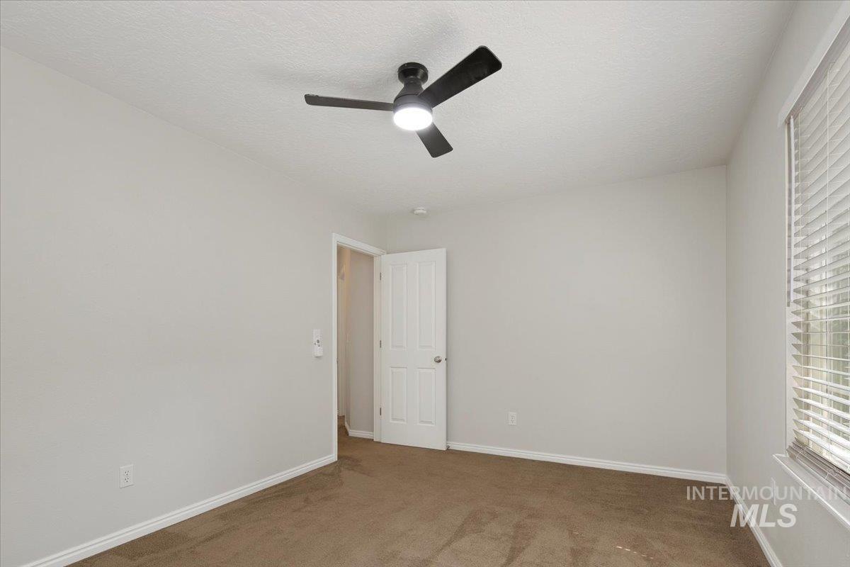 Unfurnished bedroom featuring carpet, a ceiling fan, and a textured ceiling