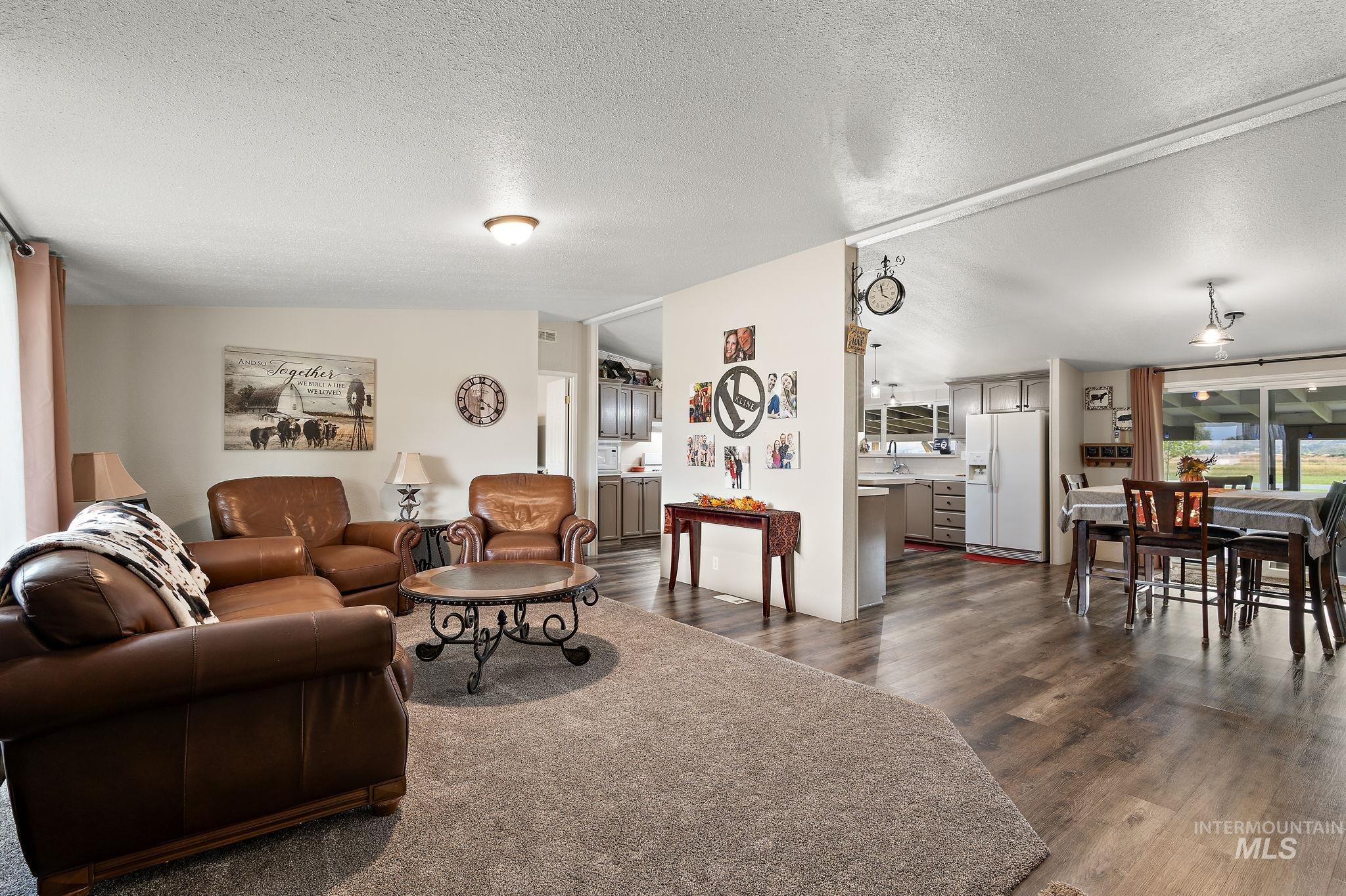 Living area with a textured ceiling and dark wood-style floors