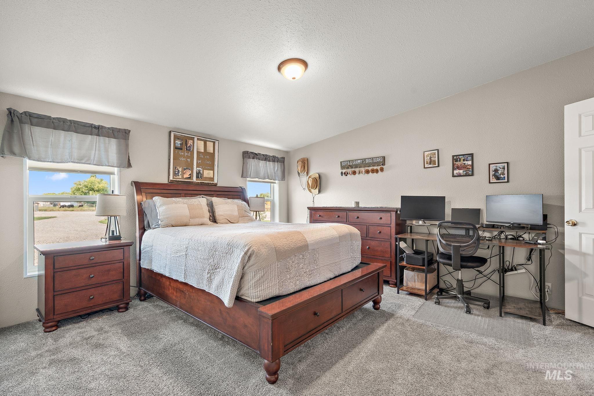 Bedroom with carpet, a desk, and a textured ceiling