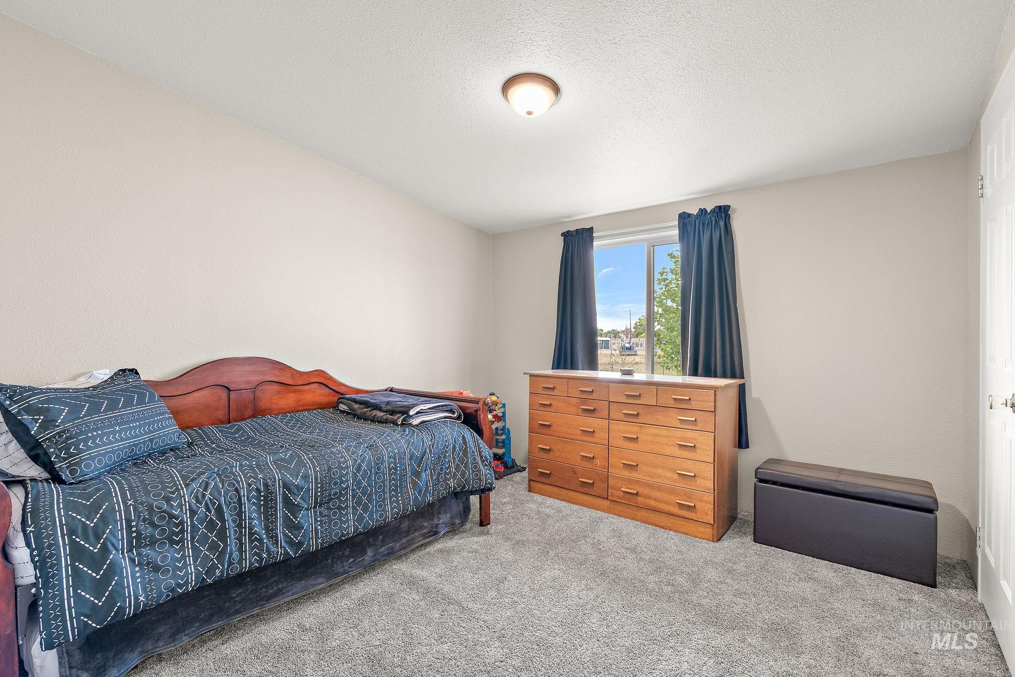 Bedroom with carpet flooring and a textured ceiling
