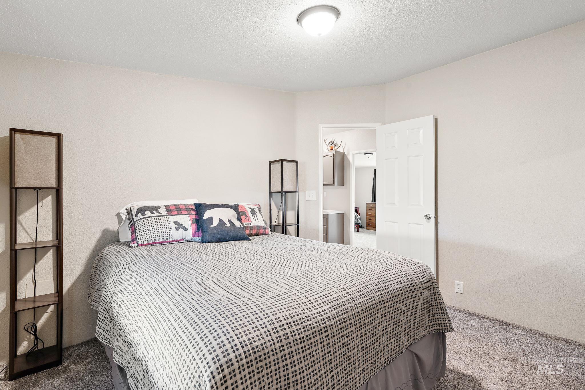 Bedroom featuring carpet flooring and a textured ceiling
