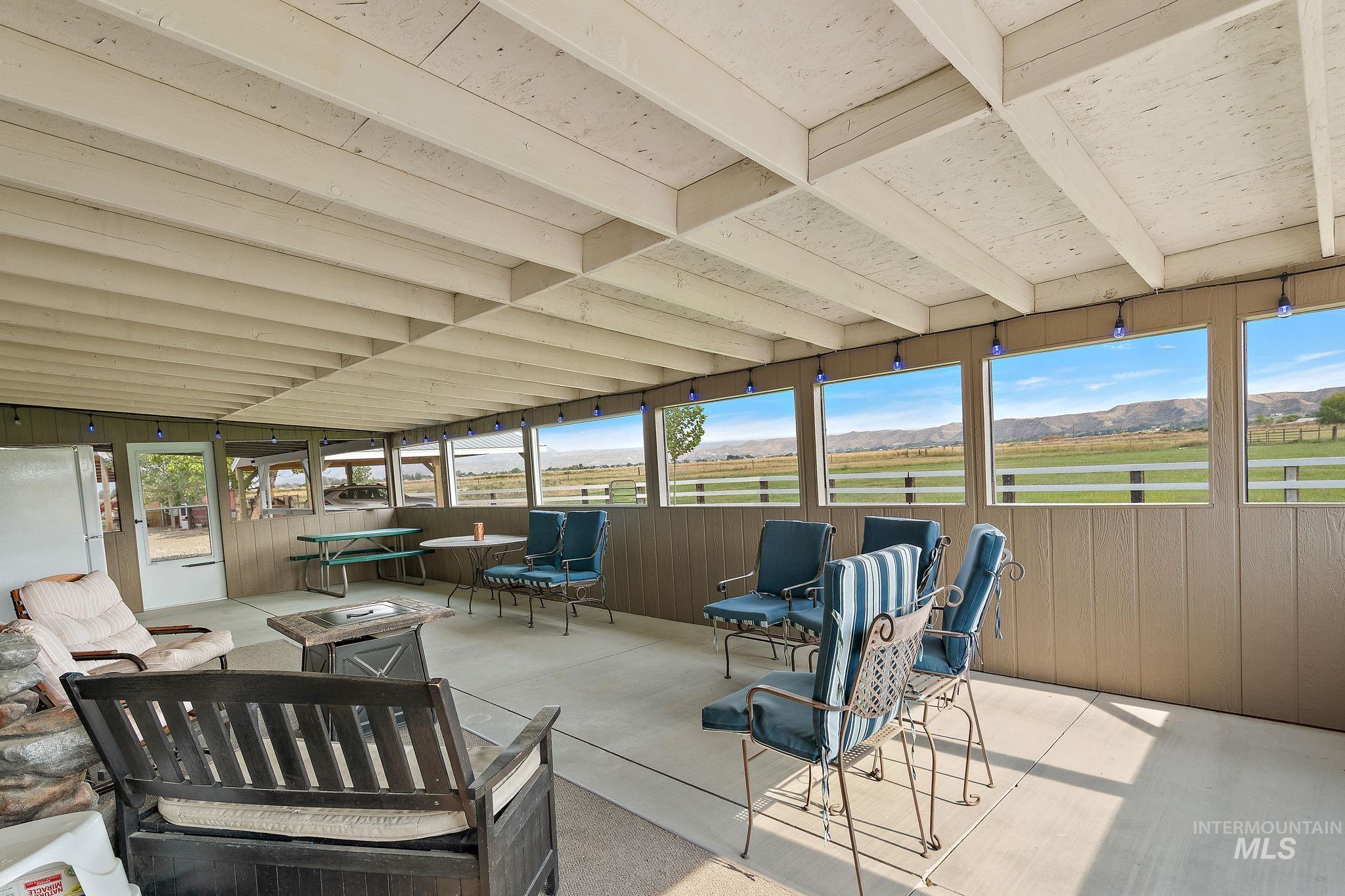 View of patio / terrace featuring a fire pit, a sunroom, and a mountain view
