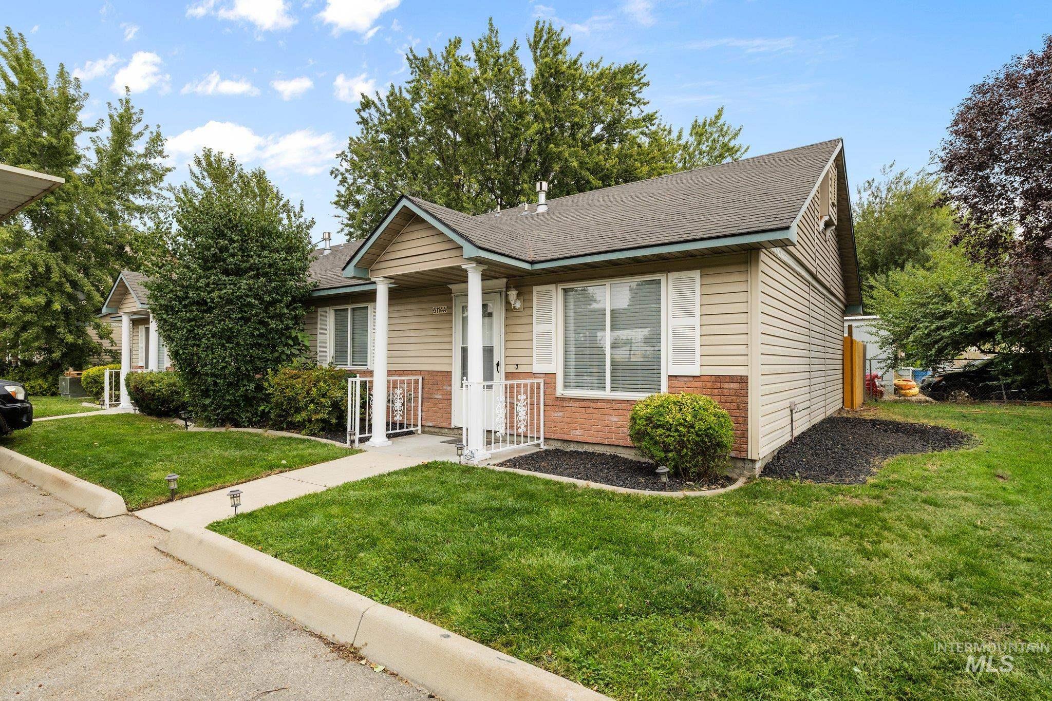 View of front facade featuring a front yard, brick siding, and a shingled roof