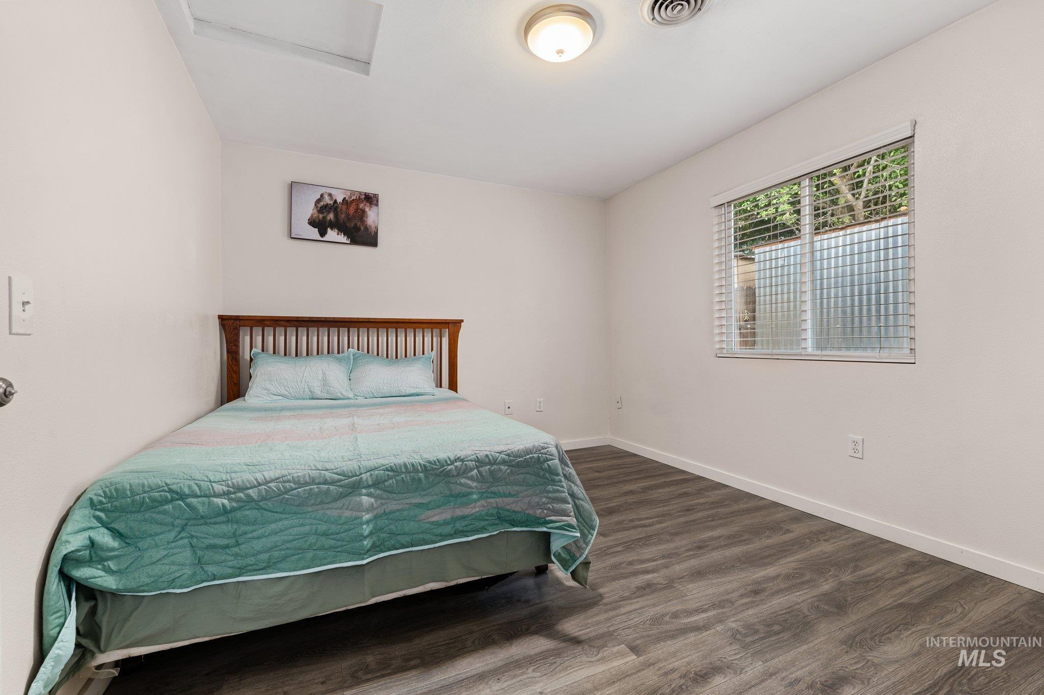 Bedroom featuring dark wood-type flooring and attic access