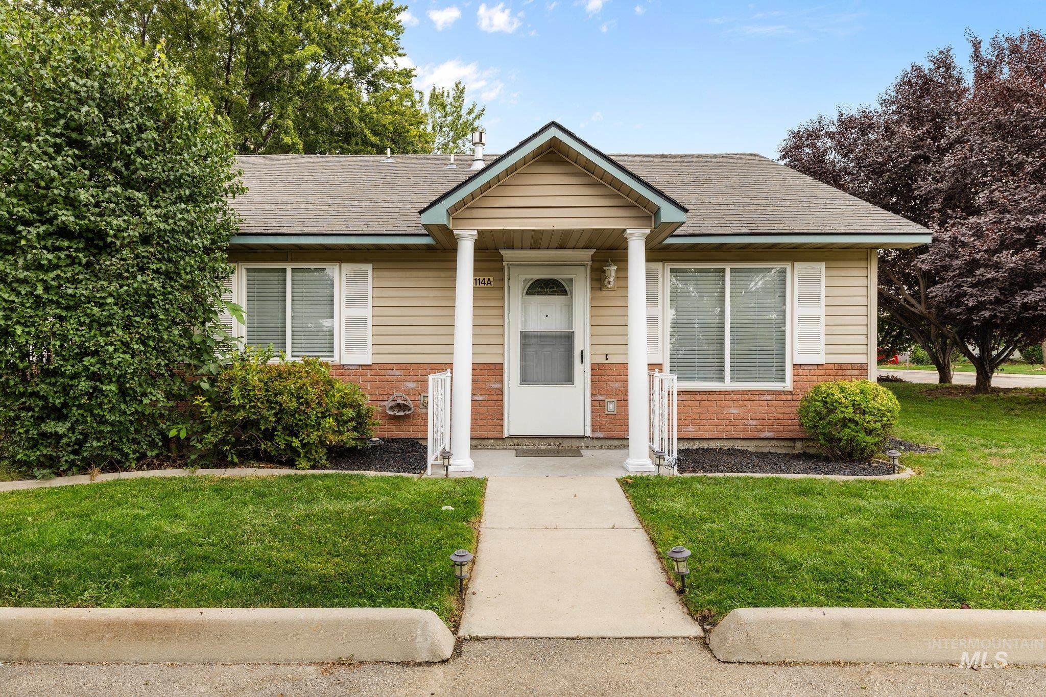 Bungalow-style home featuring brick siding, a front lawn, and roof with shingles