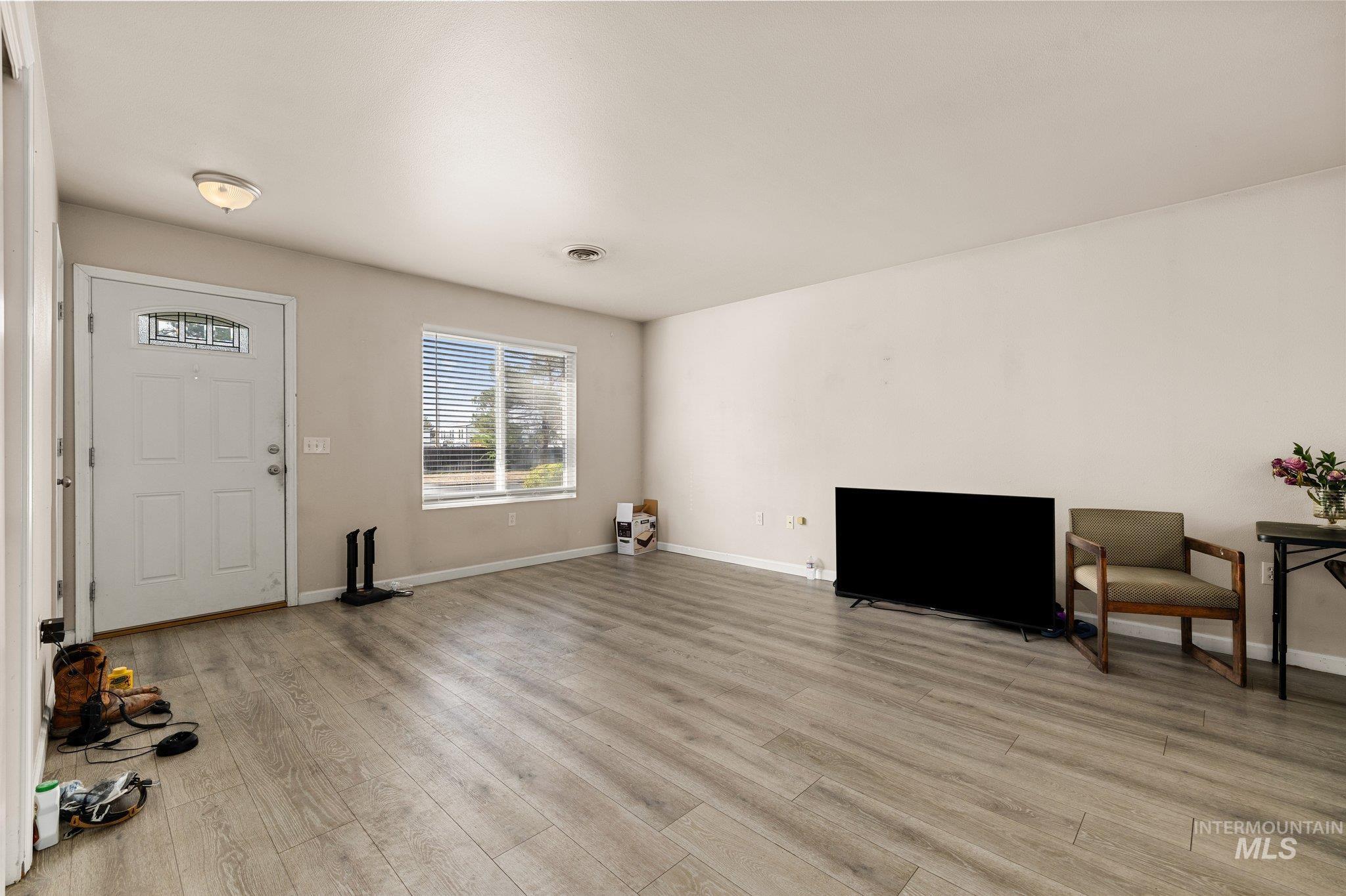 Entrance foyer featuring baseboards and light wood-type flooring
