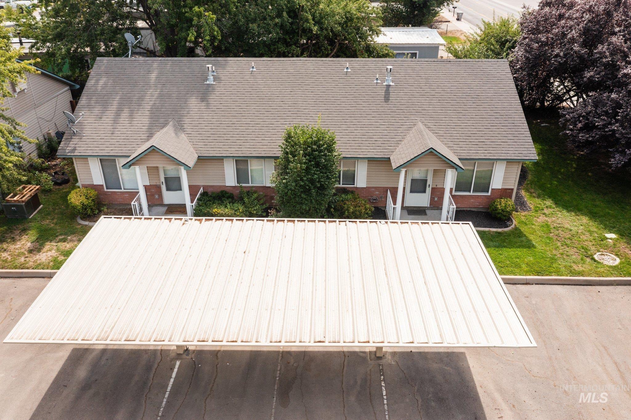 View of front of home with brick siding and roof with shingles